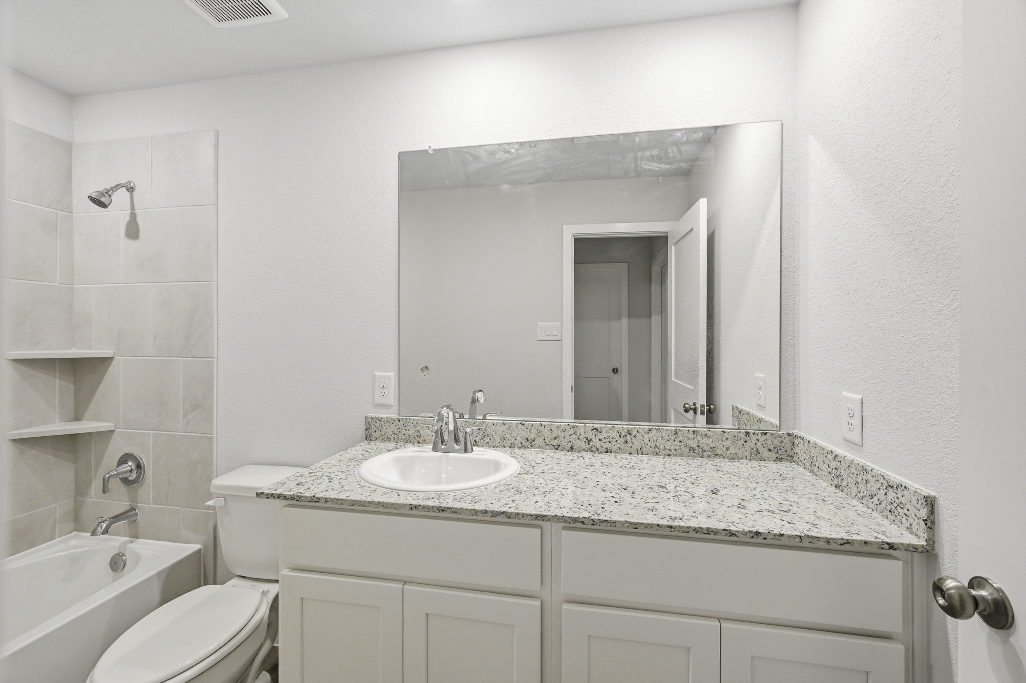 A bathroom with a large mirror.