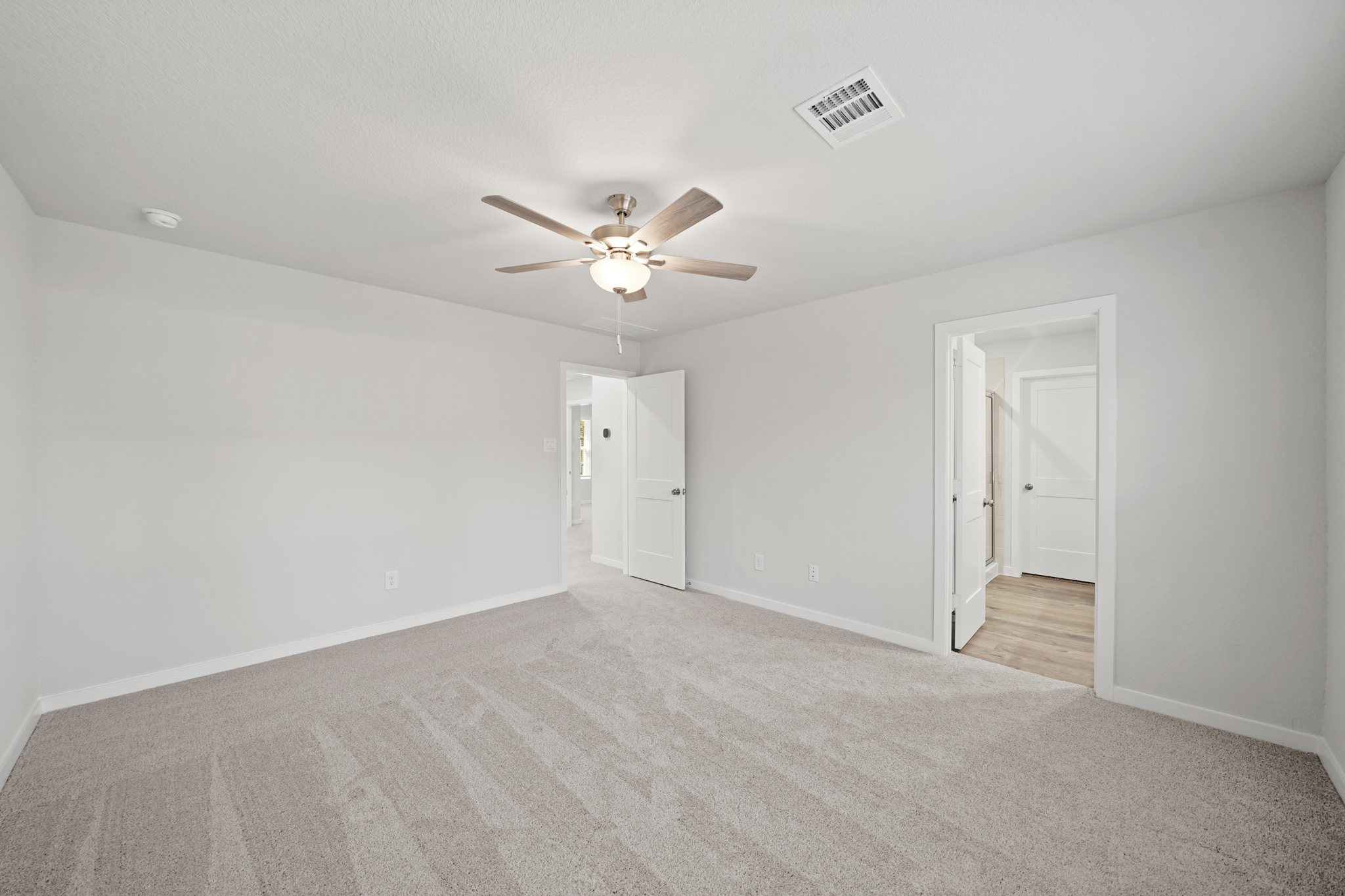 A room with white walls and a ceiling fan.