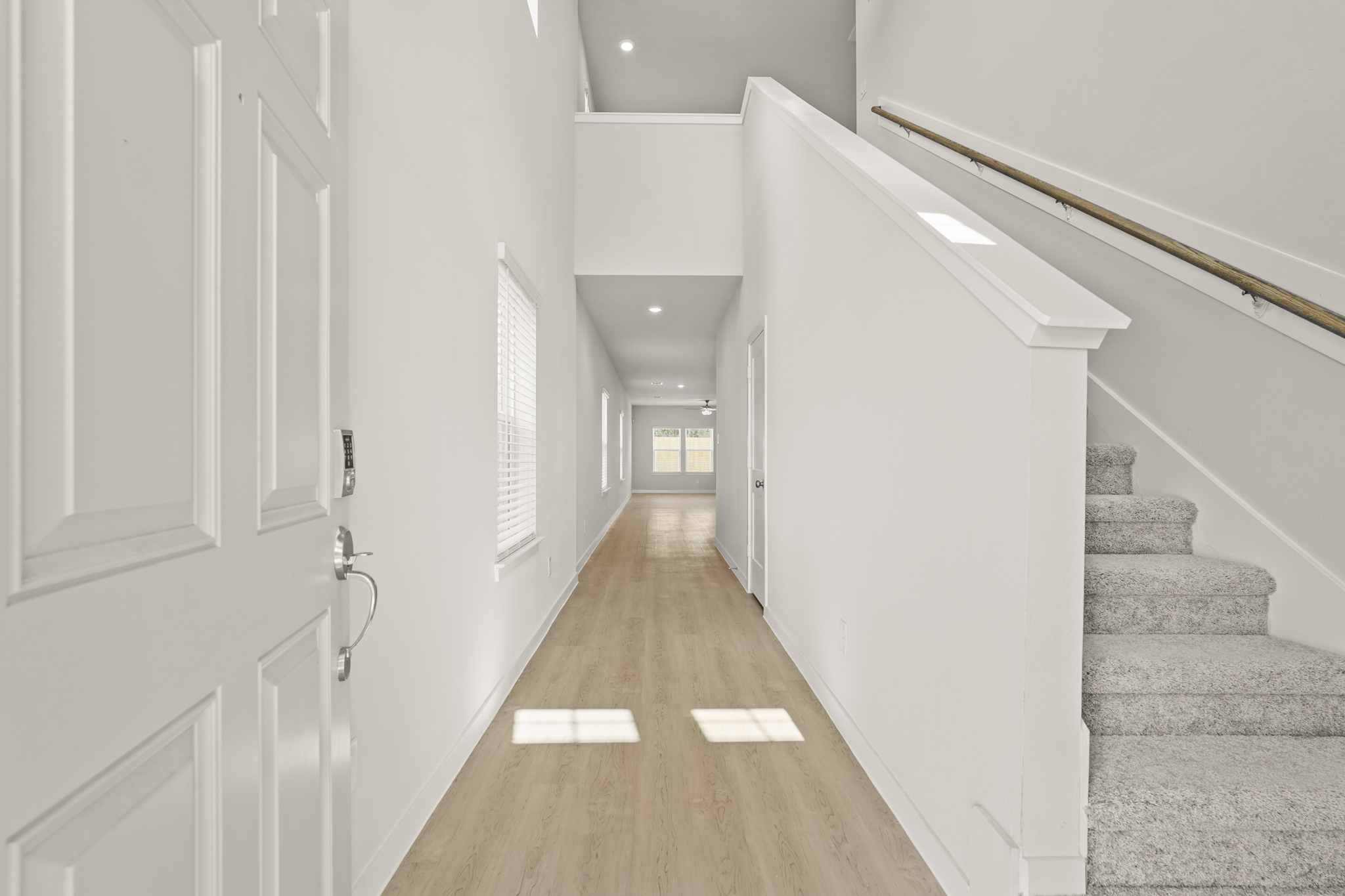 A long hallway with white doors.
