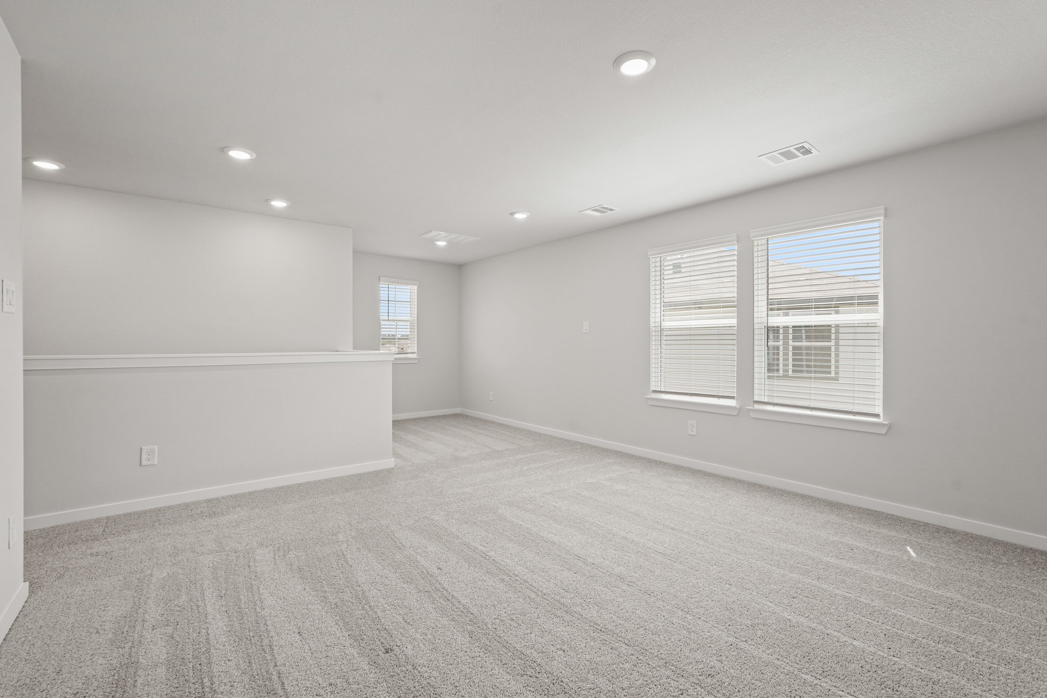 A room with a white wall and windows.