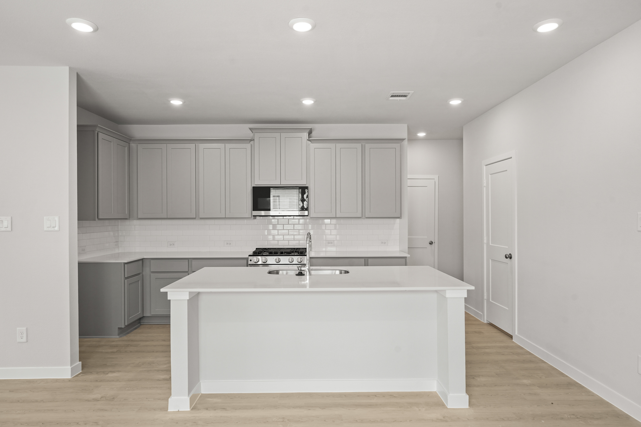 A kitchen with white cabinets.