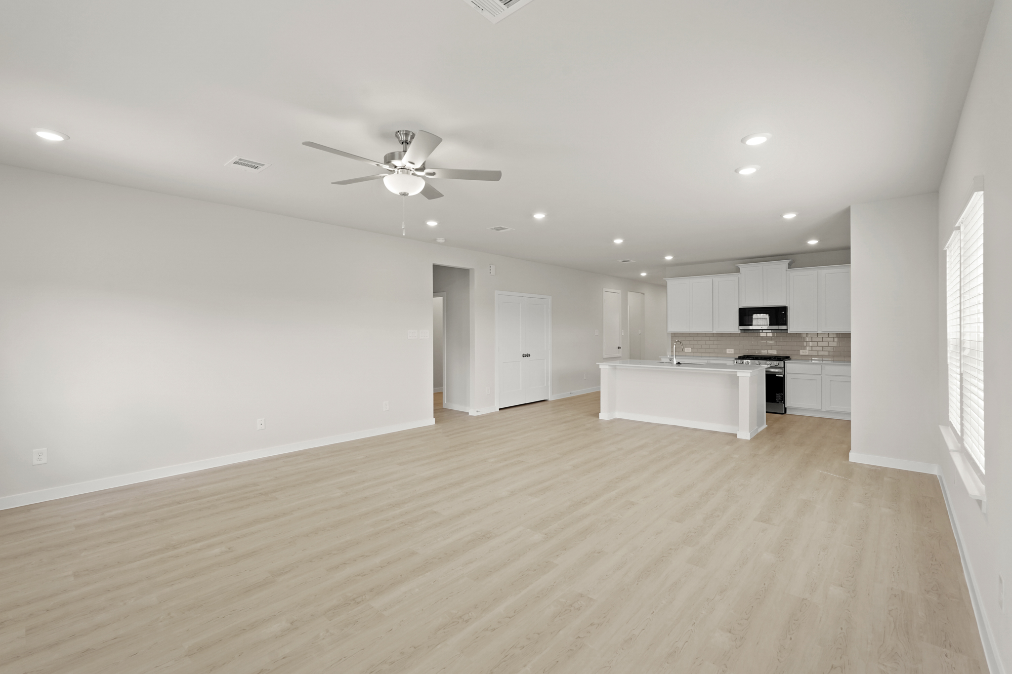 A large kitchen with a wood floor.