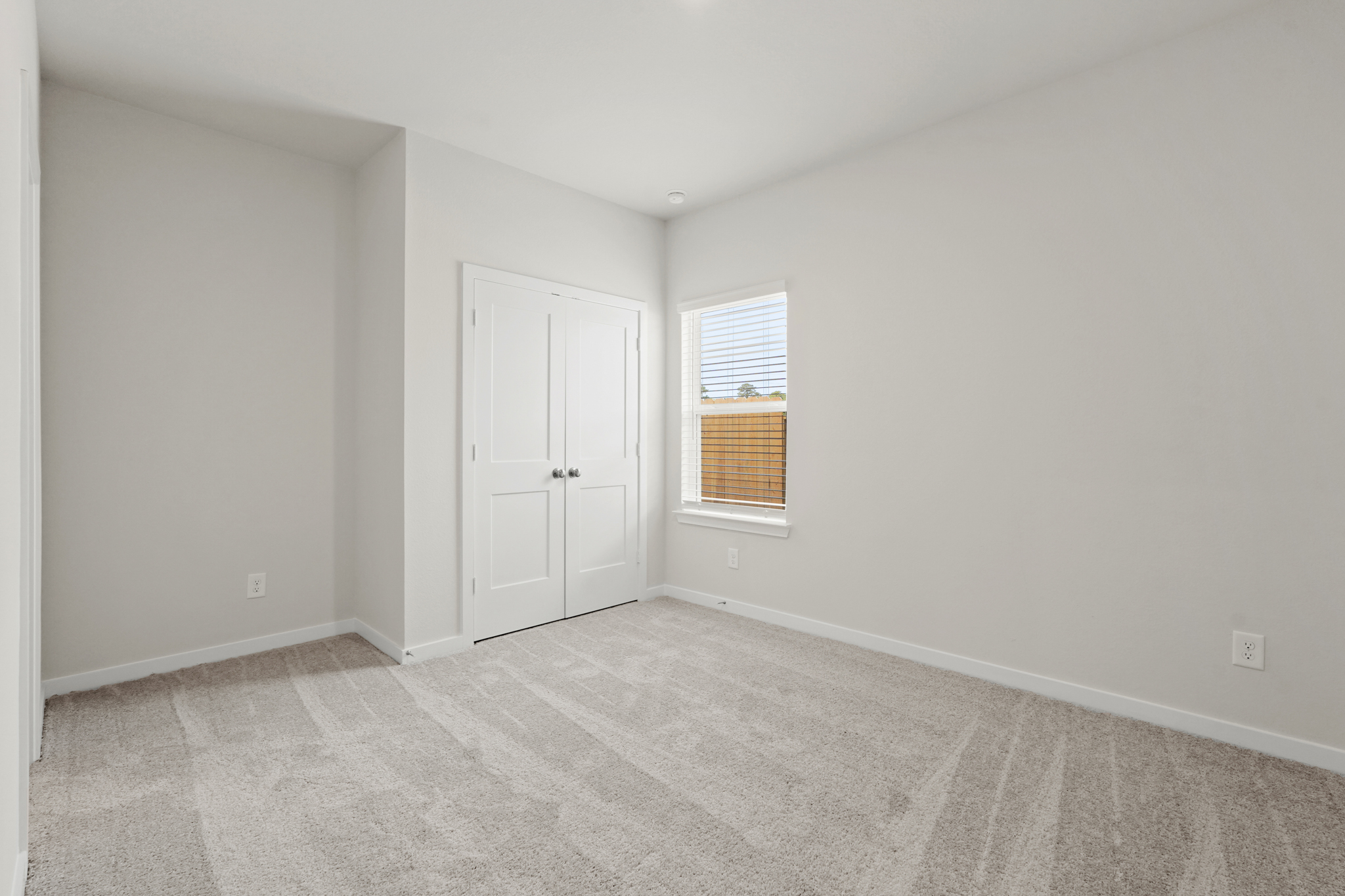 A room with white walls and a window.