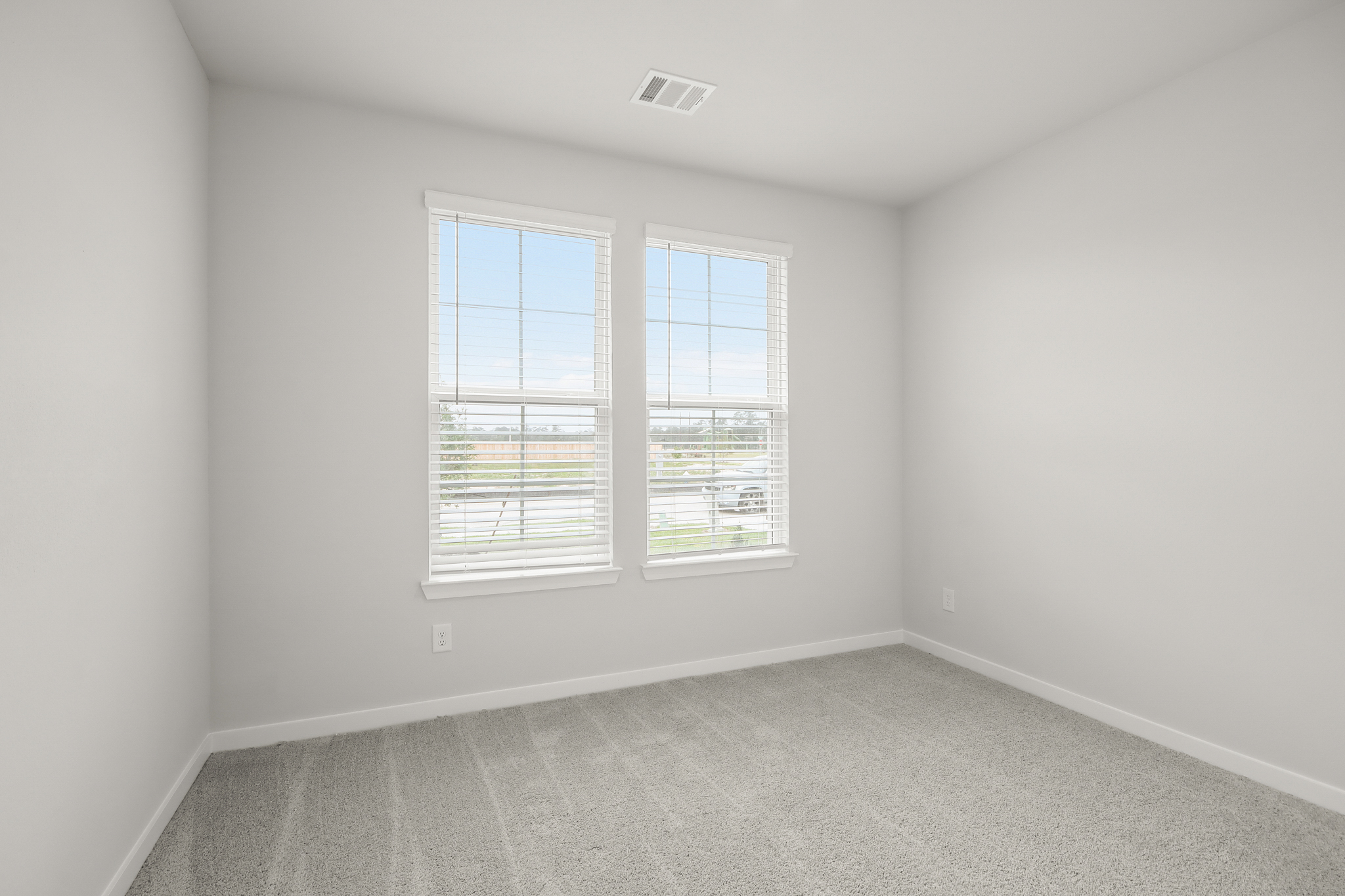 A room with a window and a carpet.