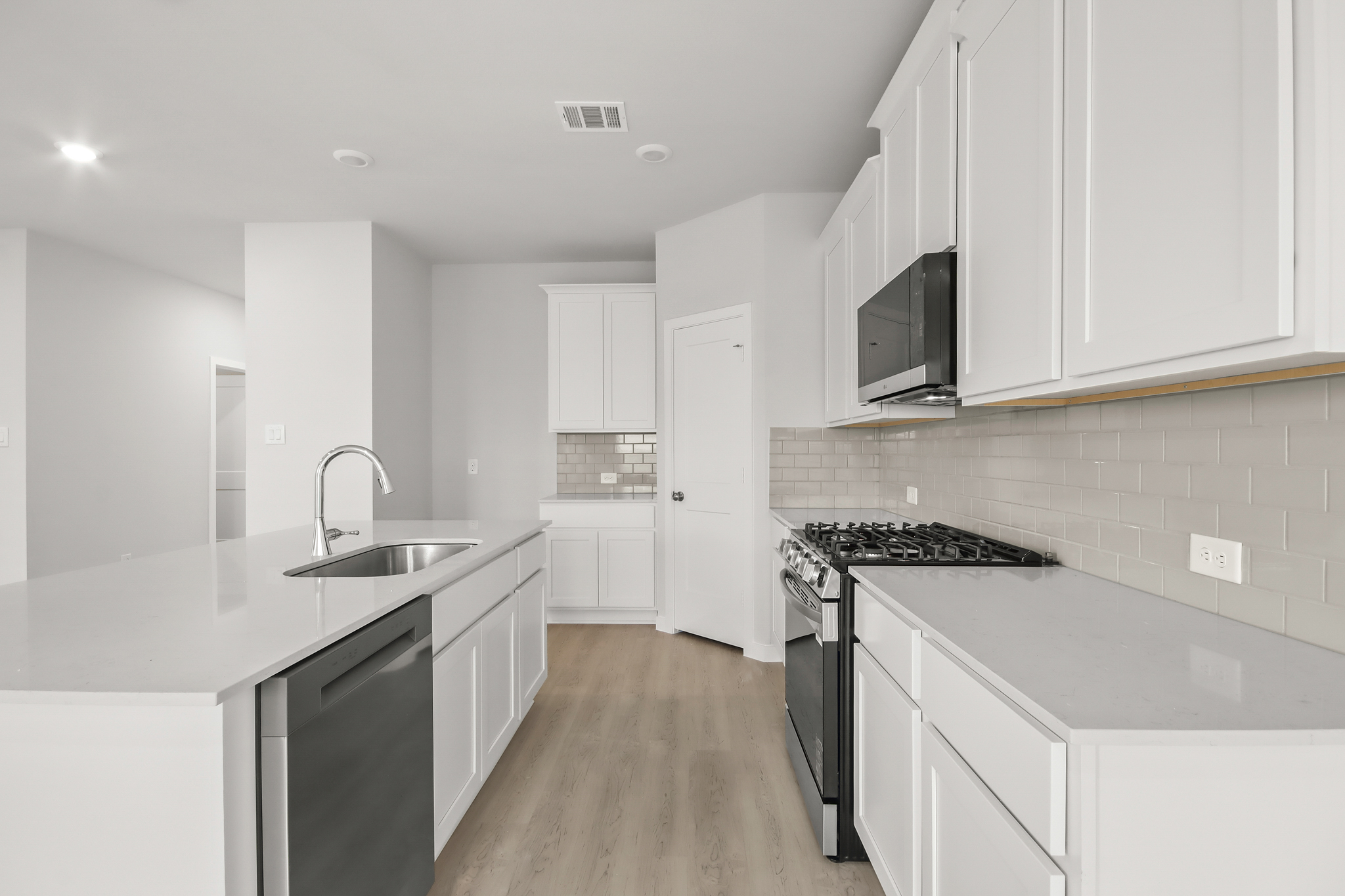 A kitchen with white cabinets.