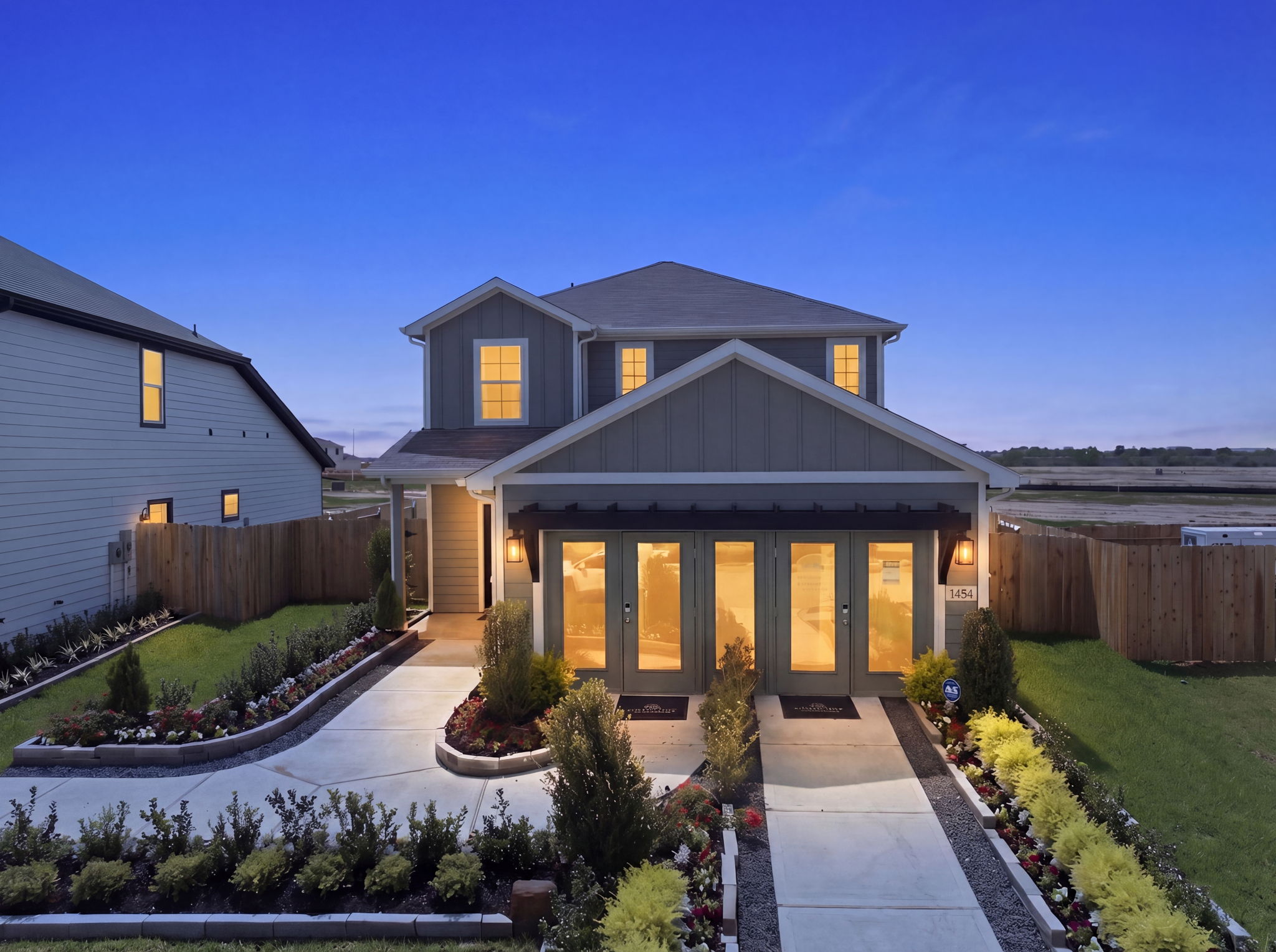 A house with a walkway and a fence and a garden.