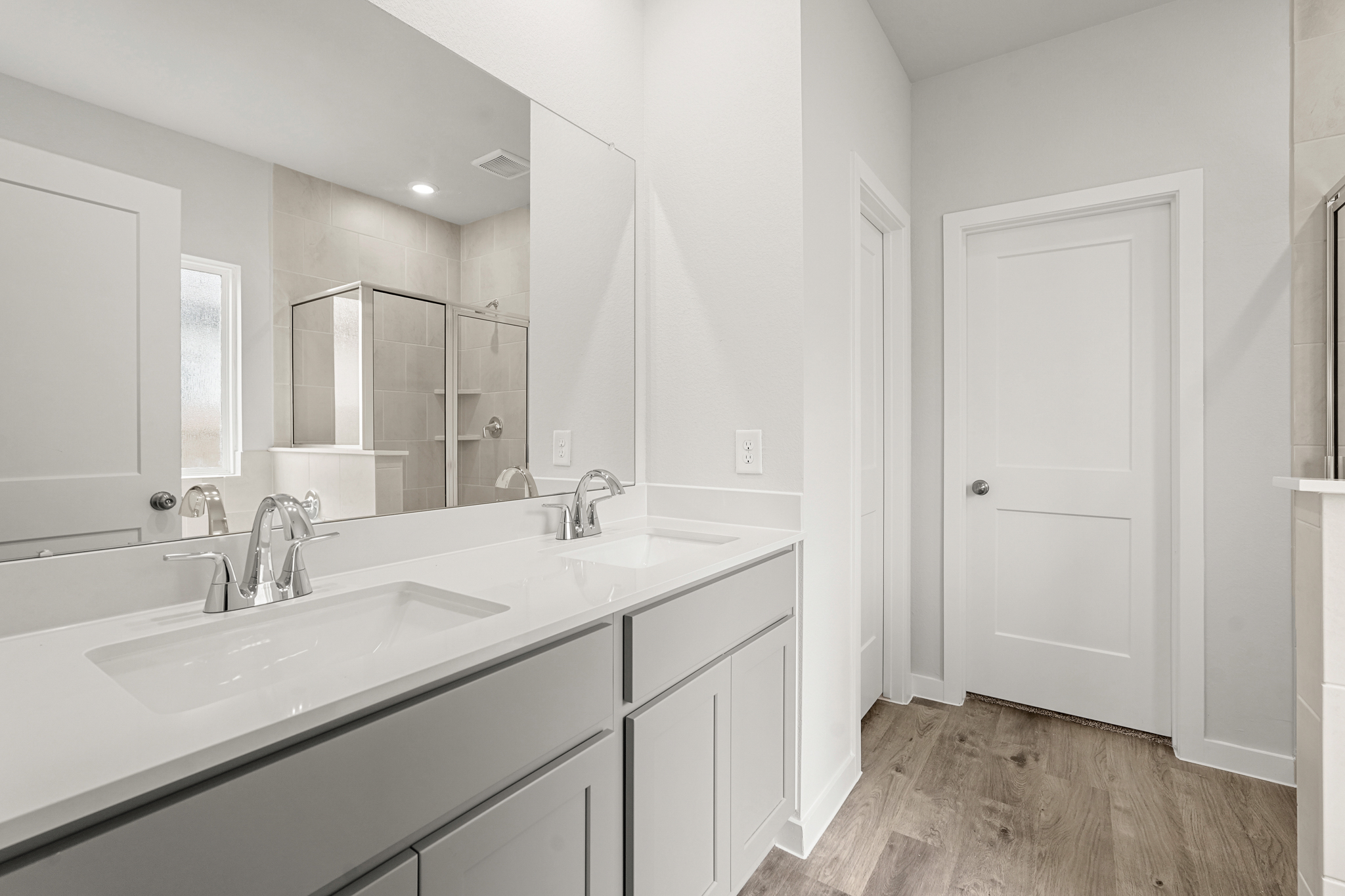 A bathroom with white cabinets.