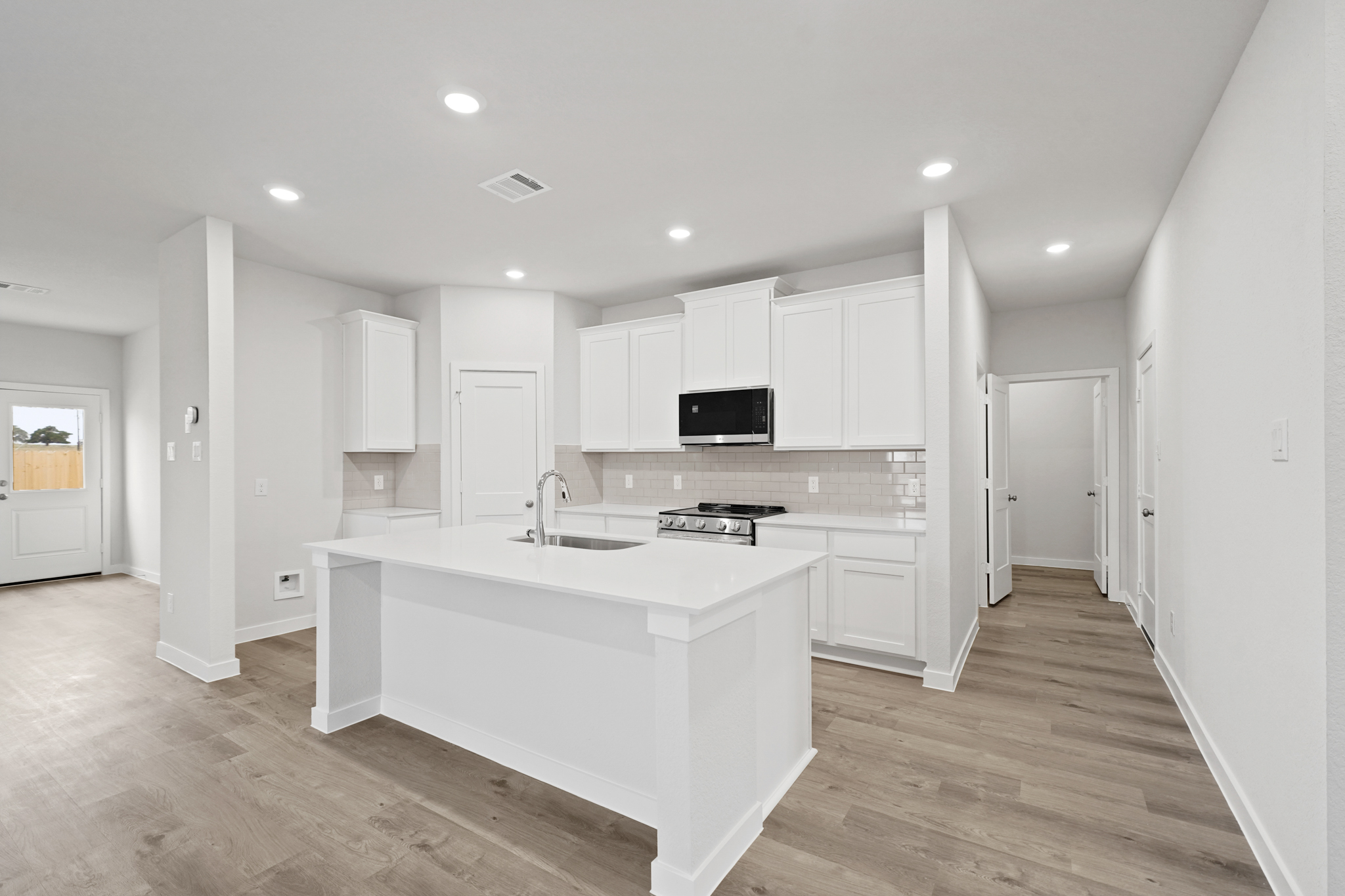 A kitchen with white cabinets.