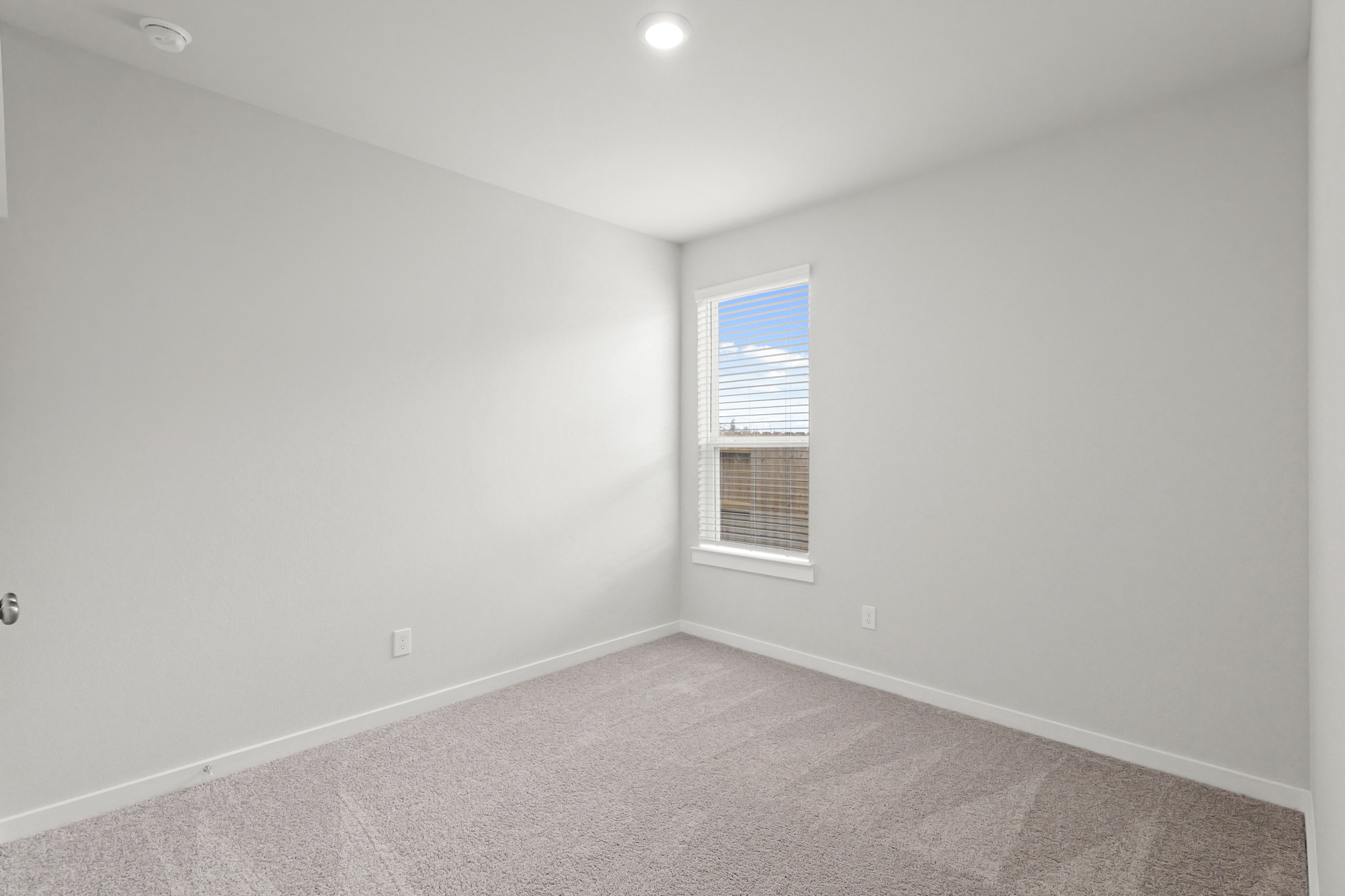A room with a window and a carpet.