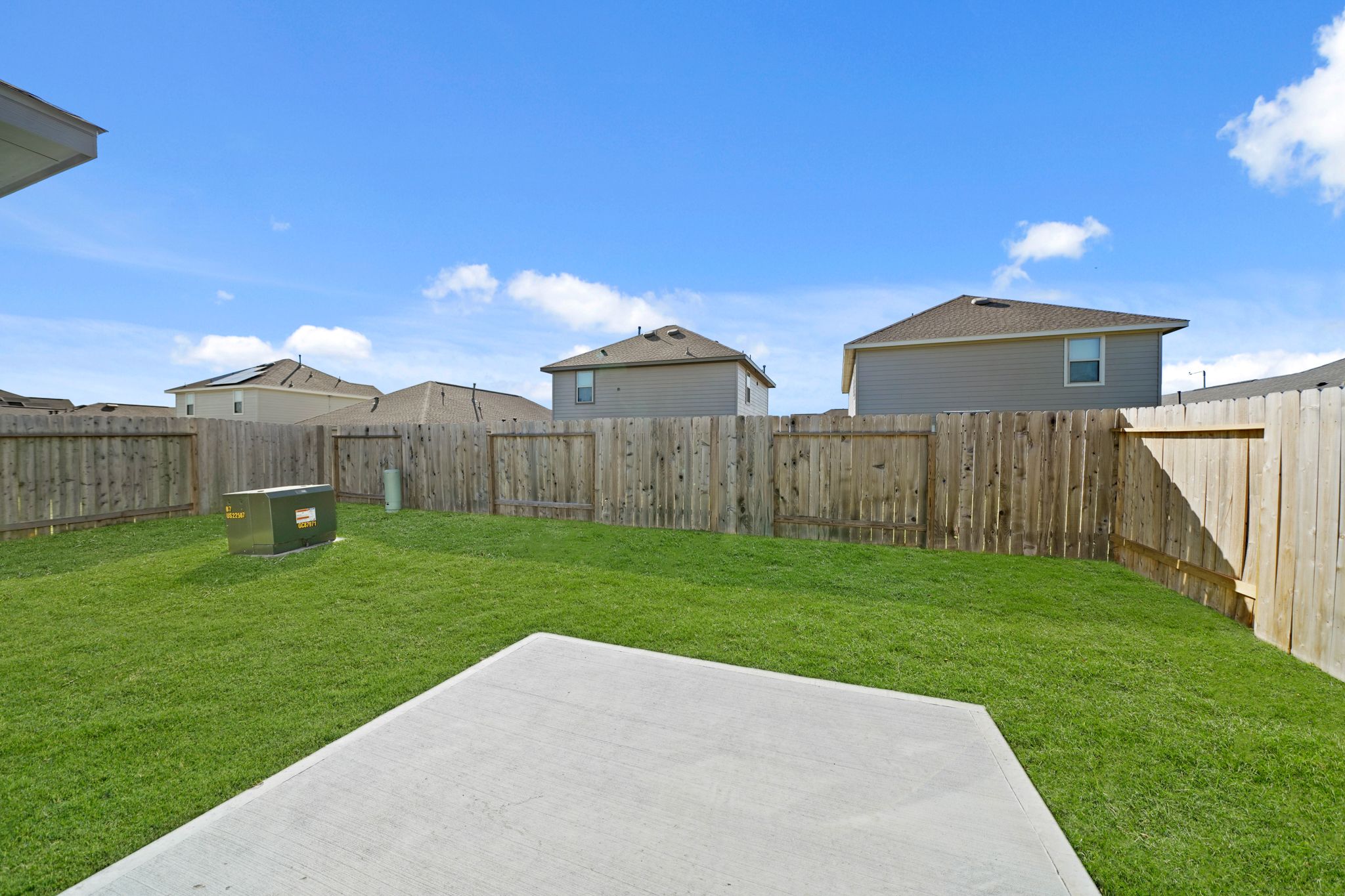 A fenced in yard with a house in the background.