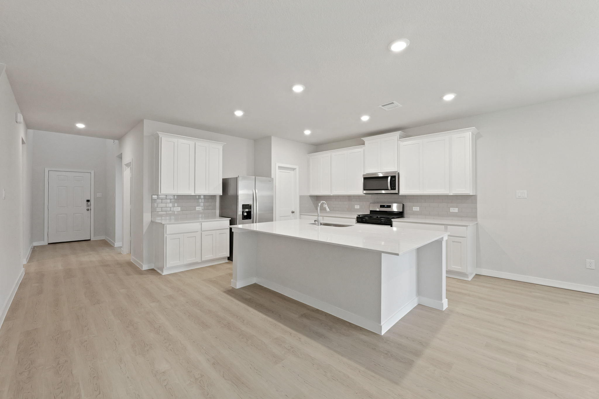 A kitchen with white cabinets.