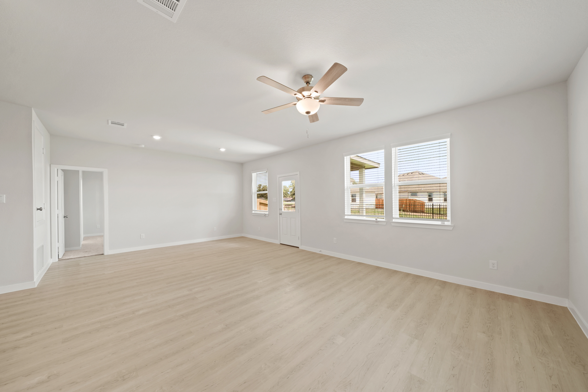 A room with a wood floor and a ceiling fan.