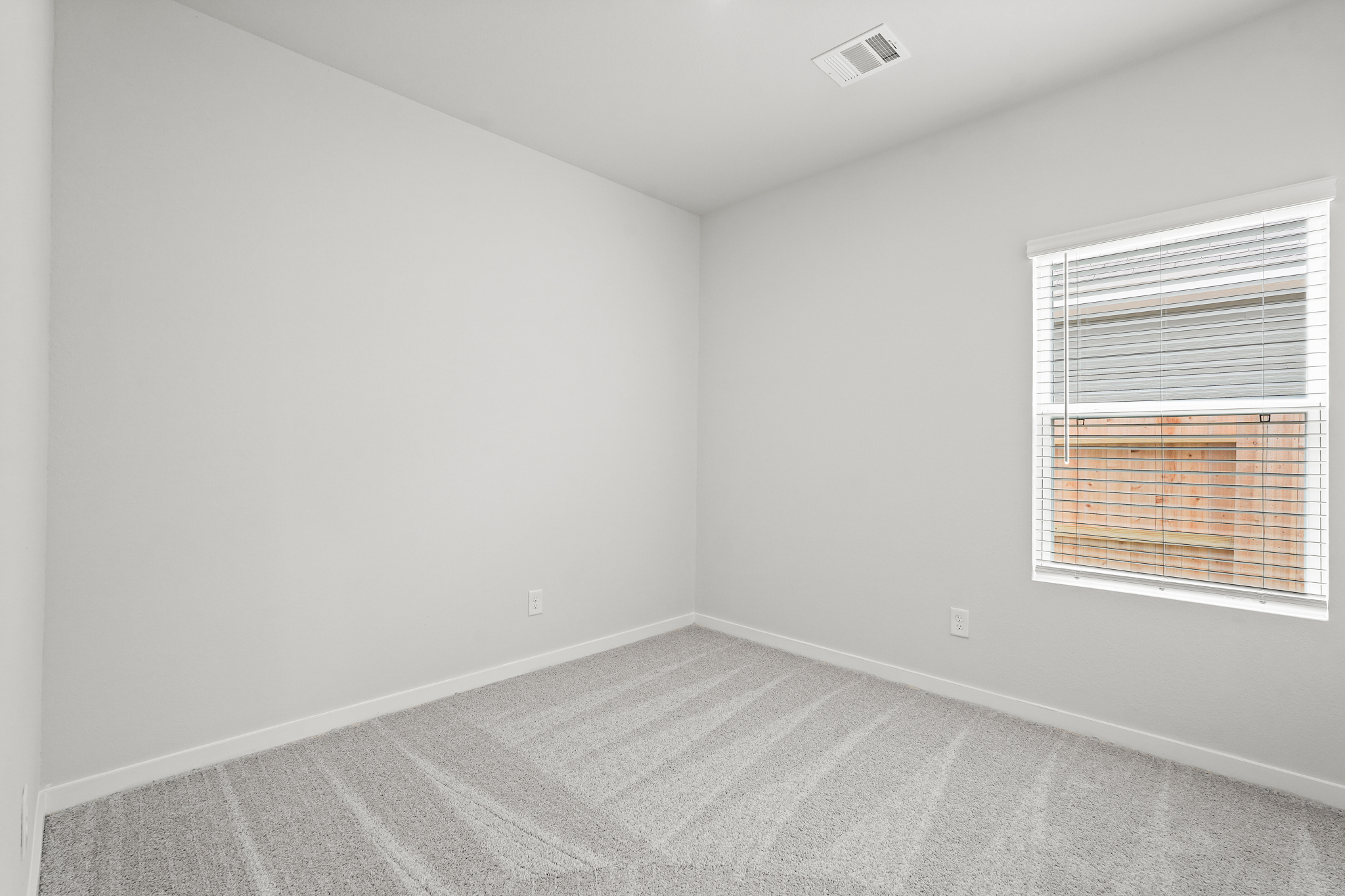 A room with a window and a carpet.