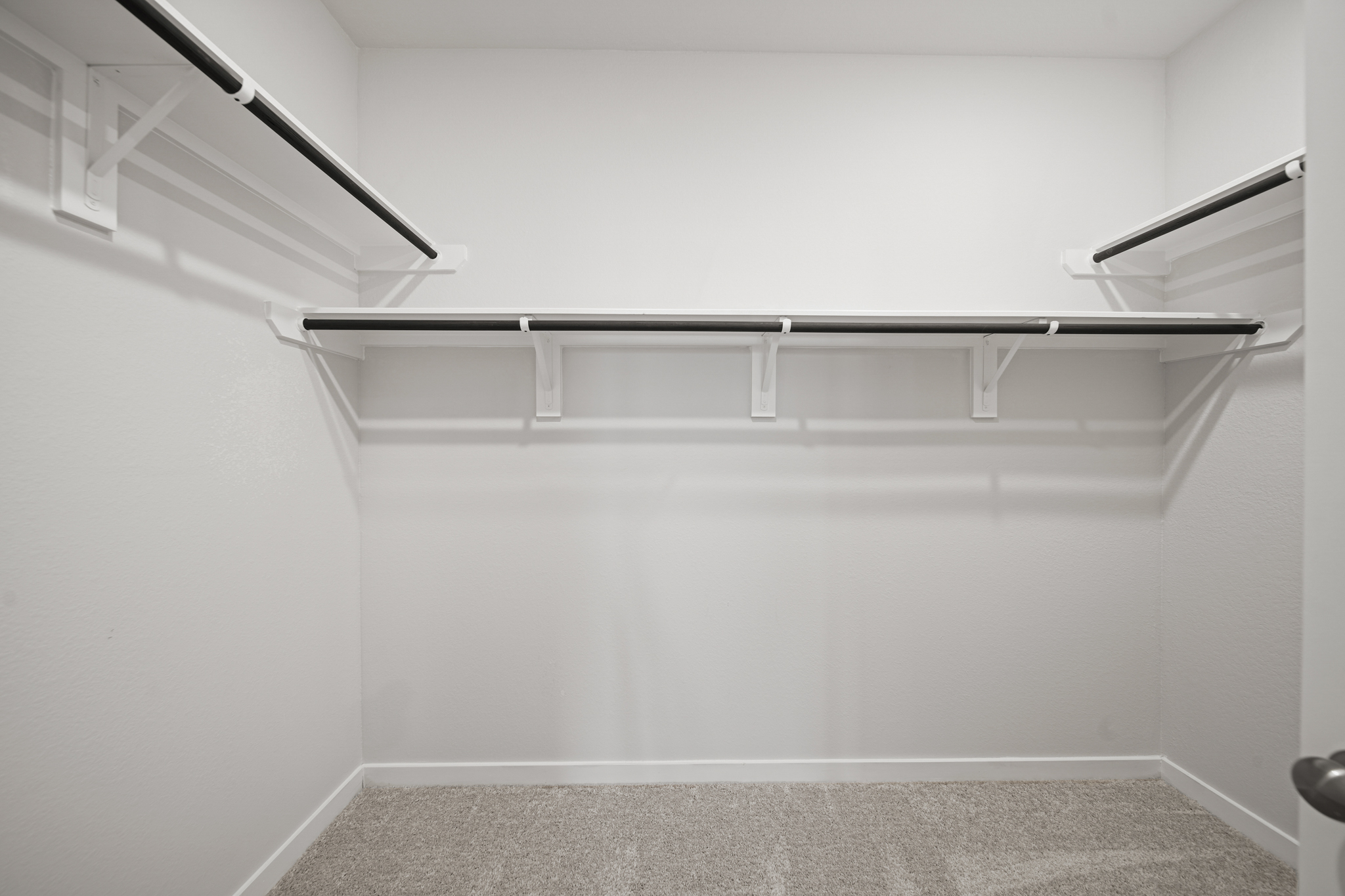 A white wall with a metal railing.