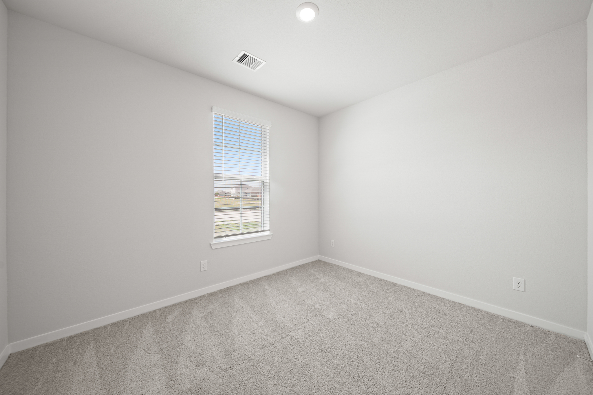 A room with a window and a carpet.
