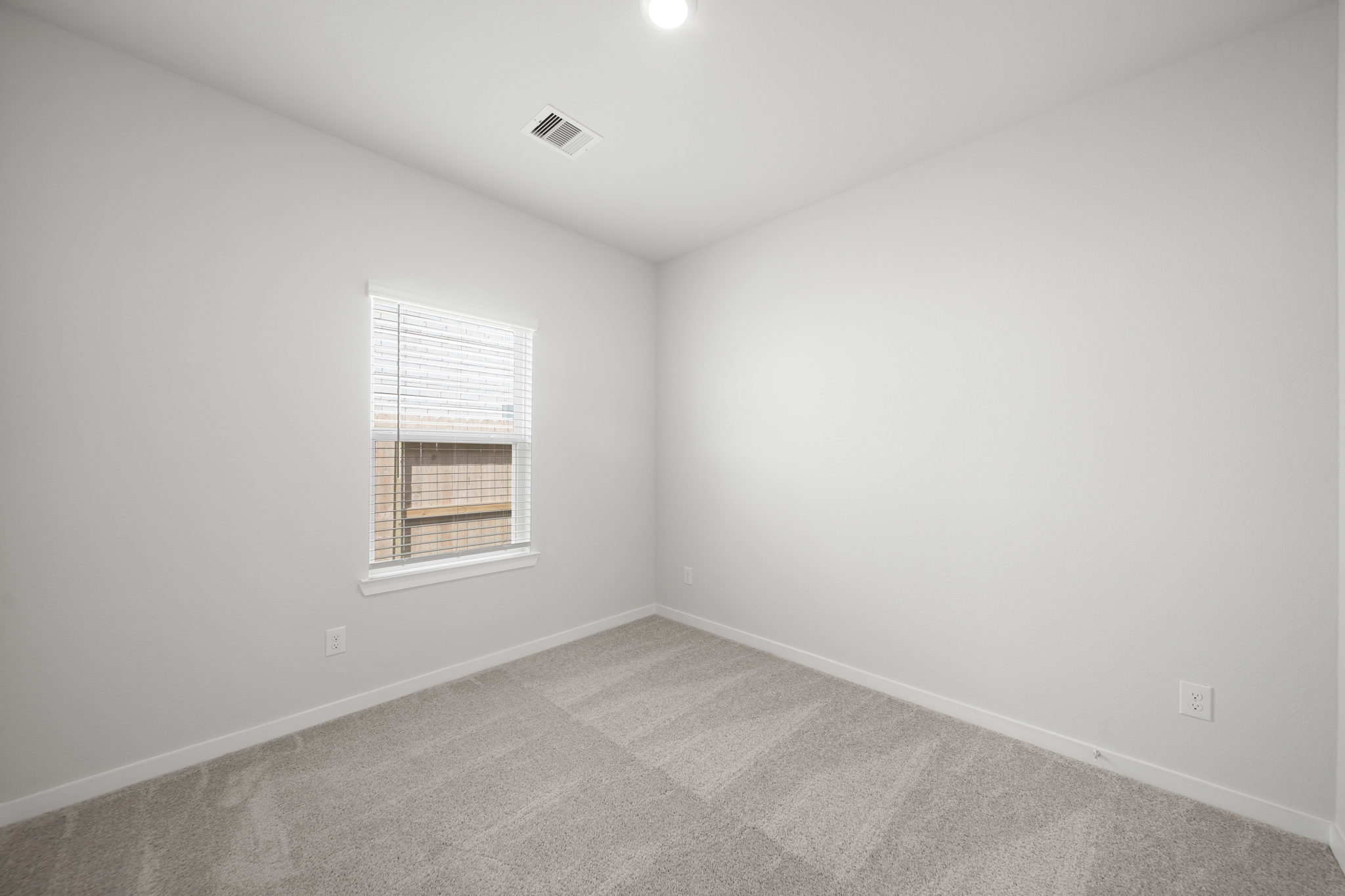 A room with a window and a carpet.