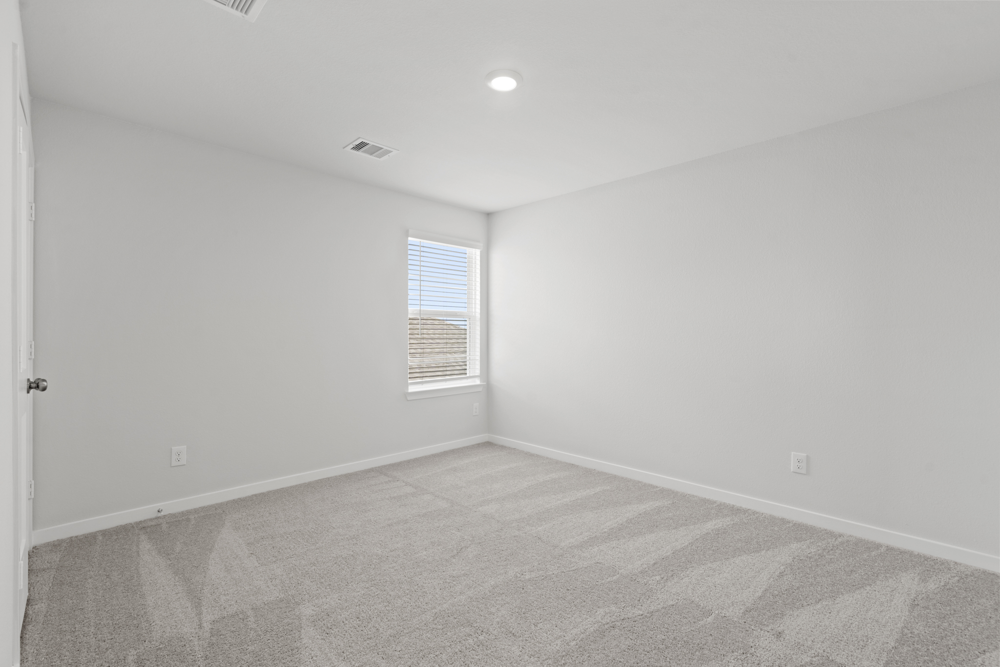A room with a carpet and a window.