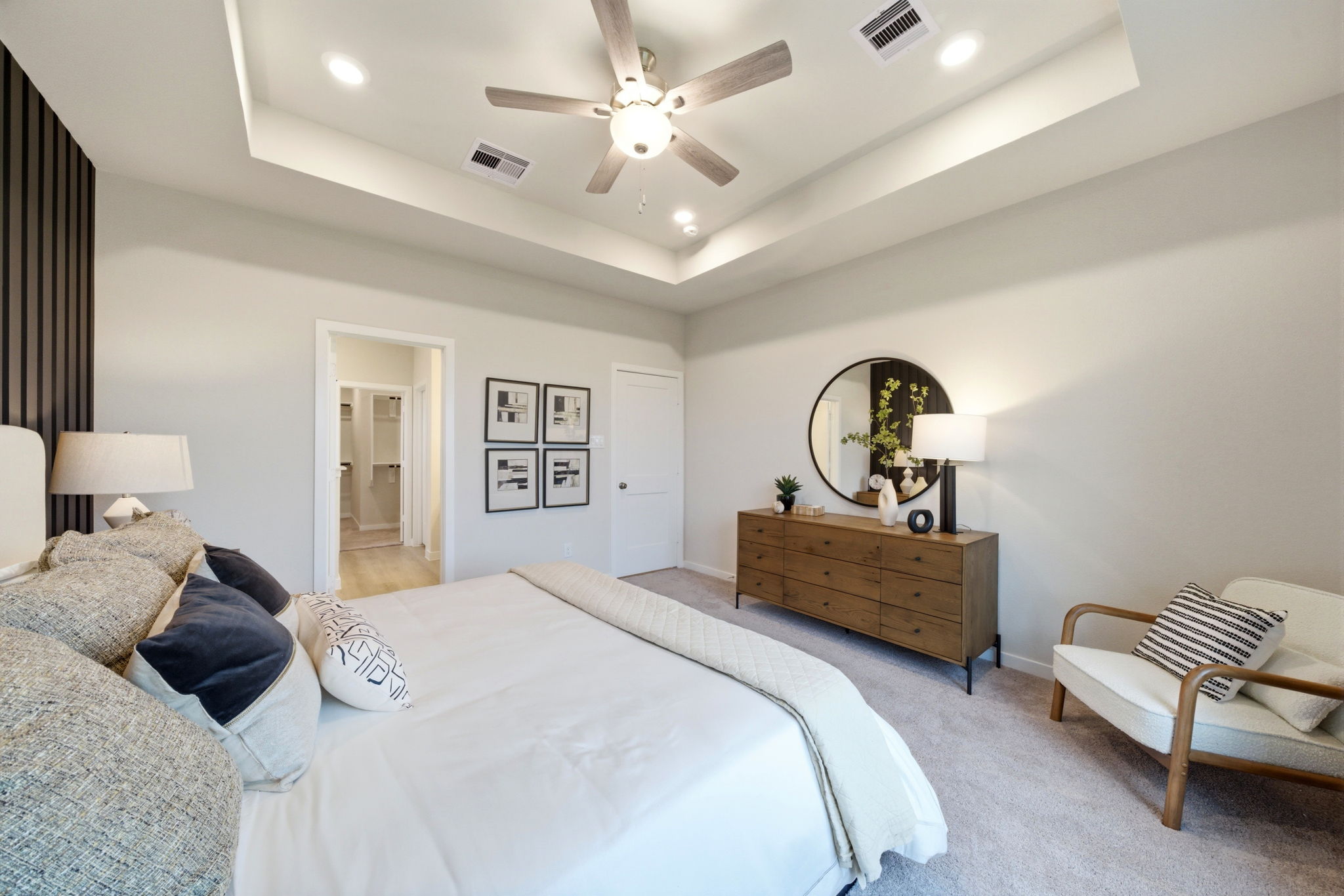 A bedroom with a bed and a chair.