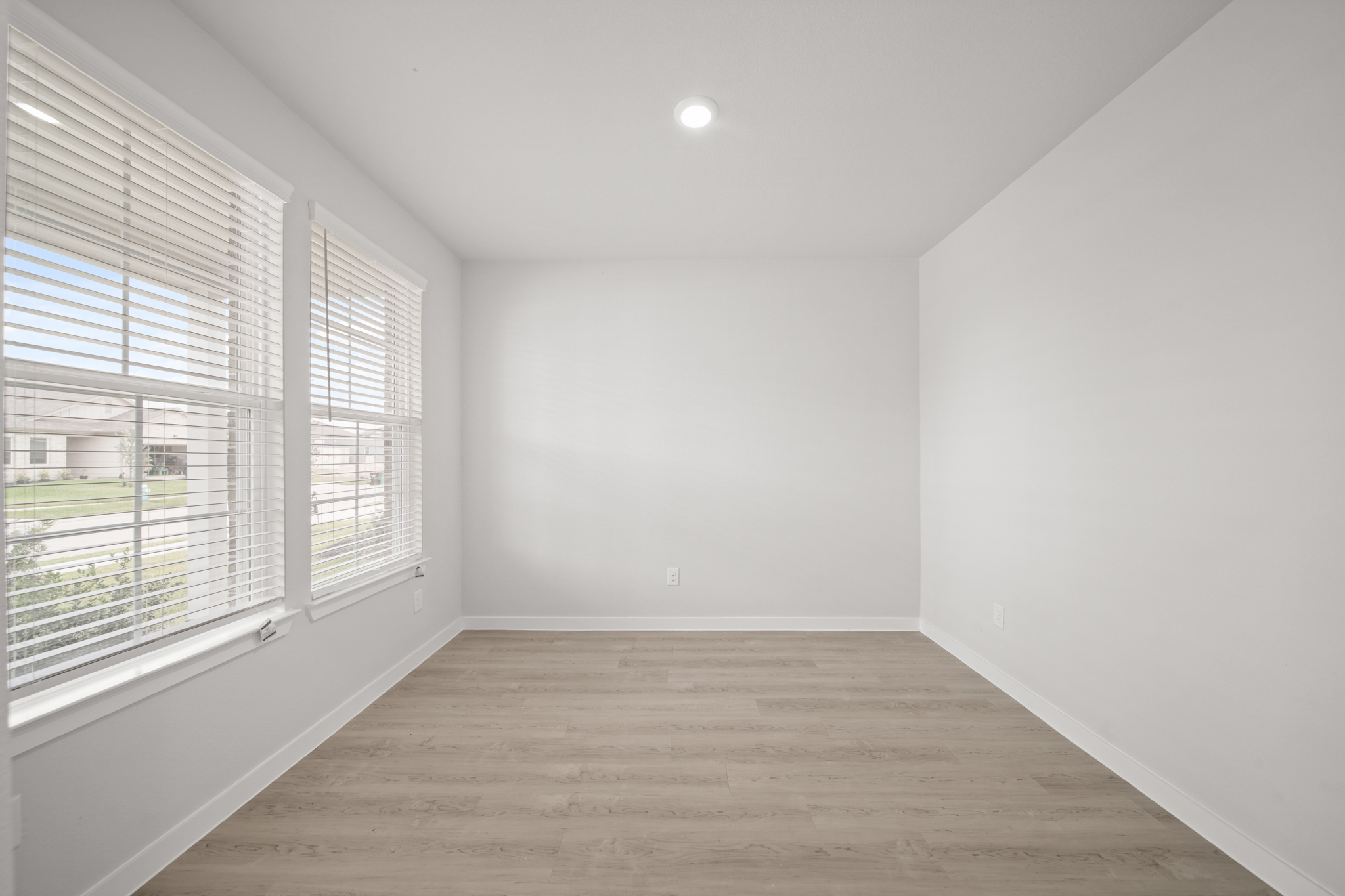 A room with a wood floor and windows.