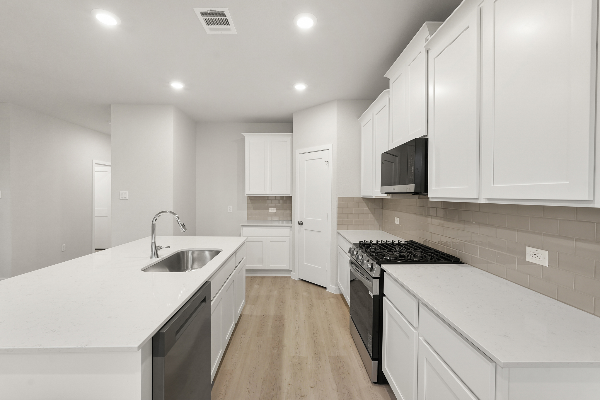 A kitchen with white cabinets.