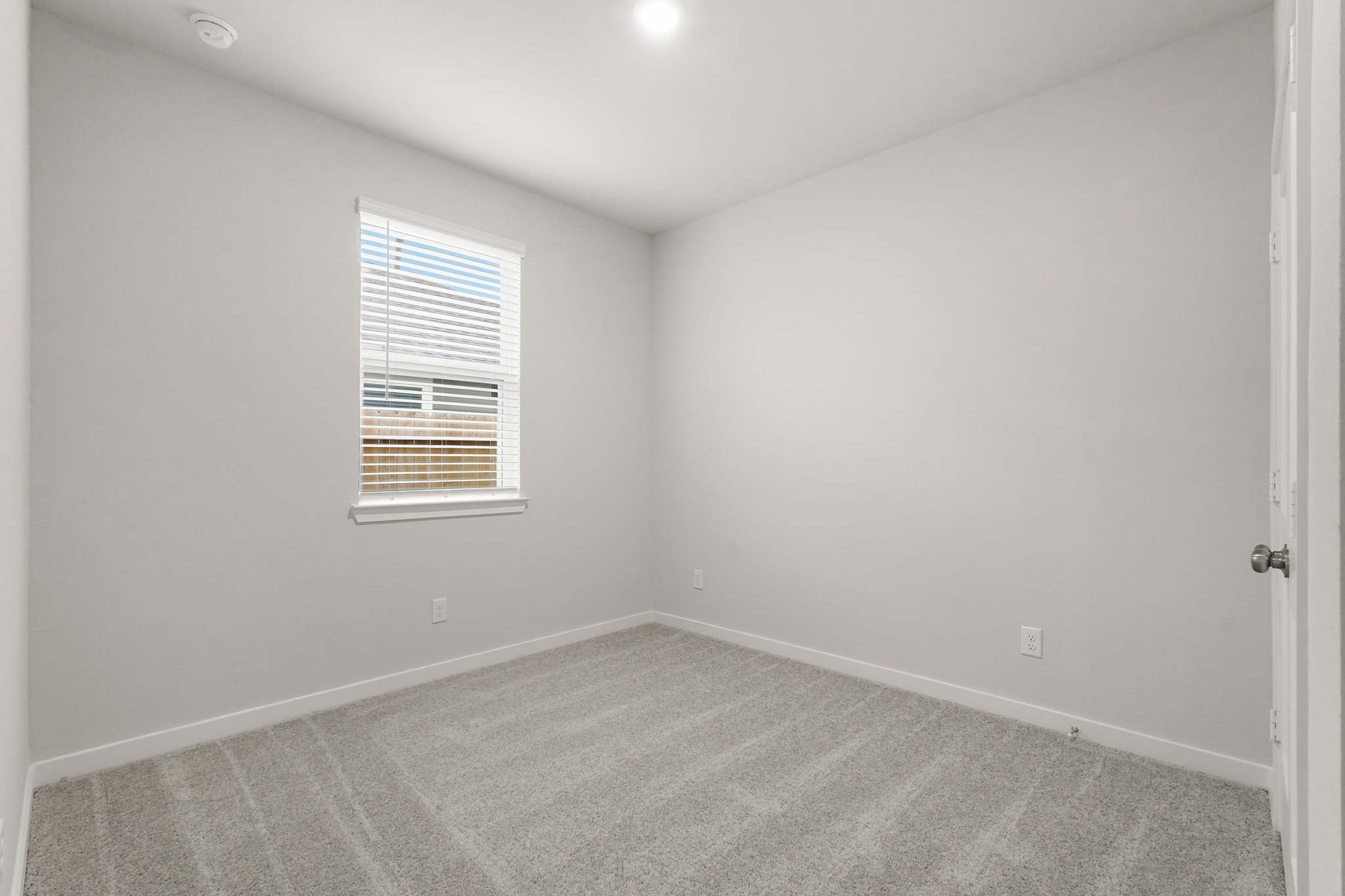 A room with a carpet and a window.