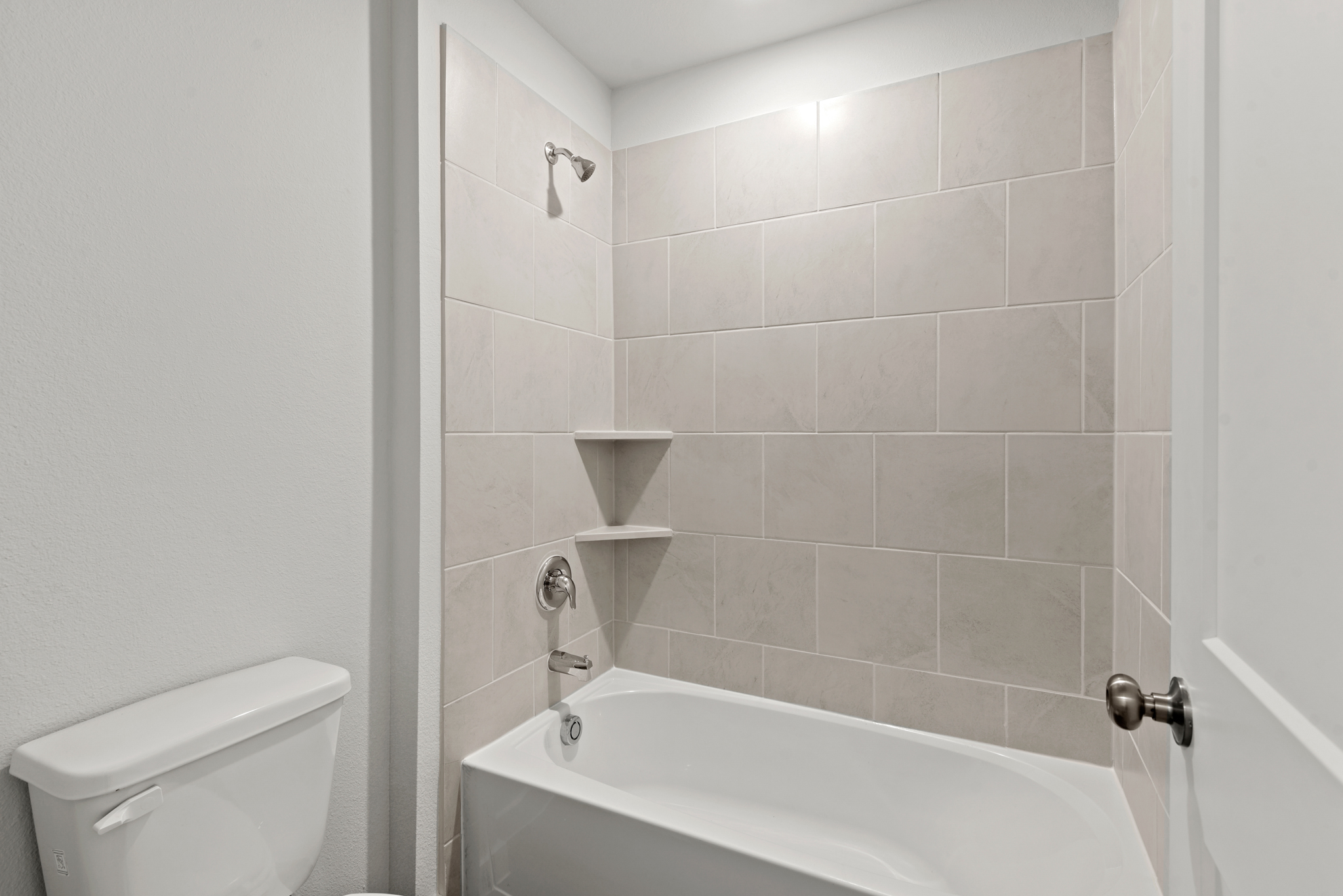 A bathroom with a tub and toilet.