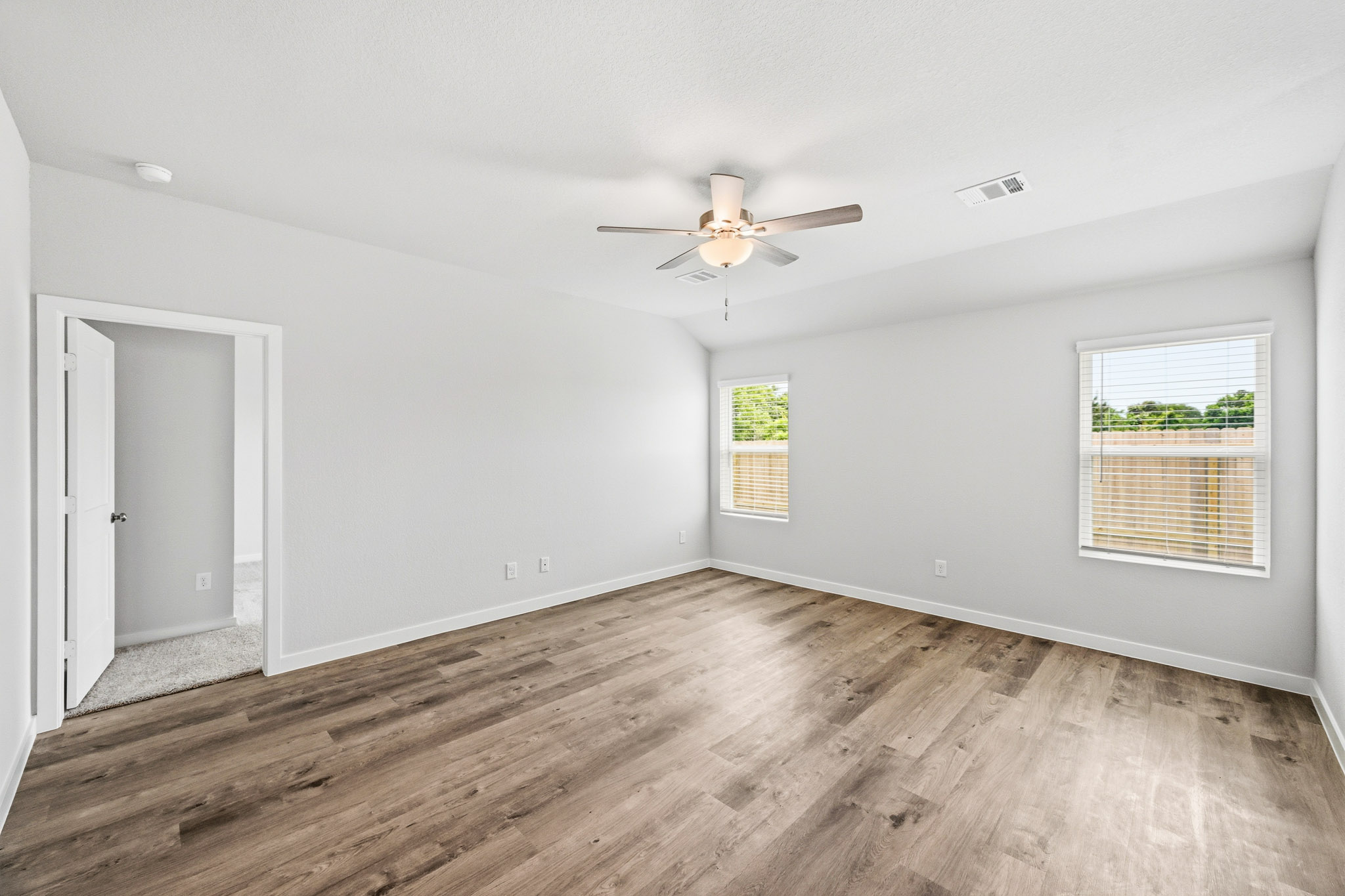 A room with a wood floor and a ceiling fan.