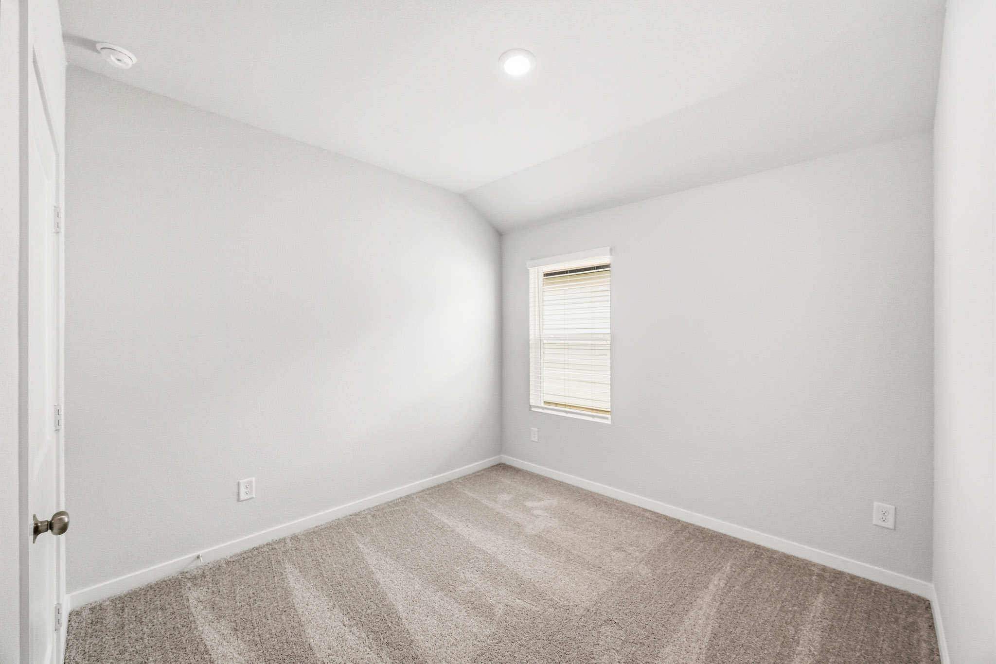 A room with a carpet and a door.