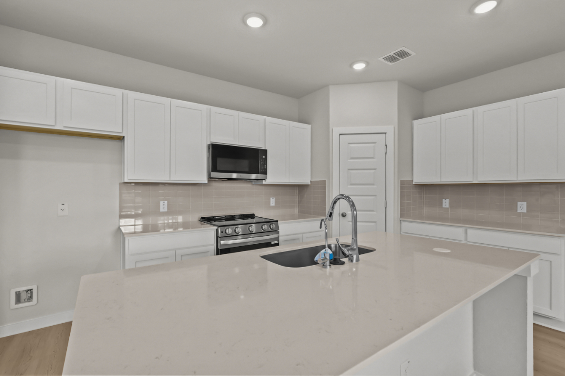 A kitchen with white cabinets.