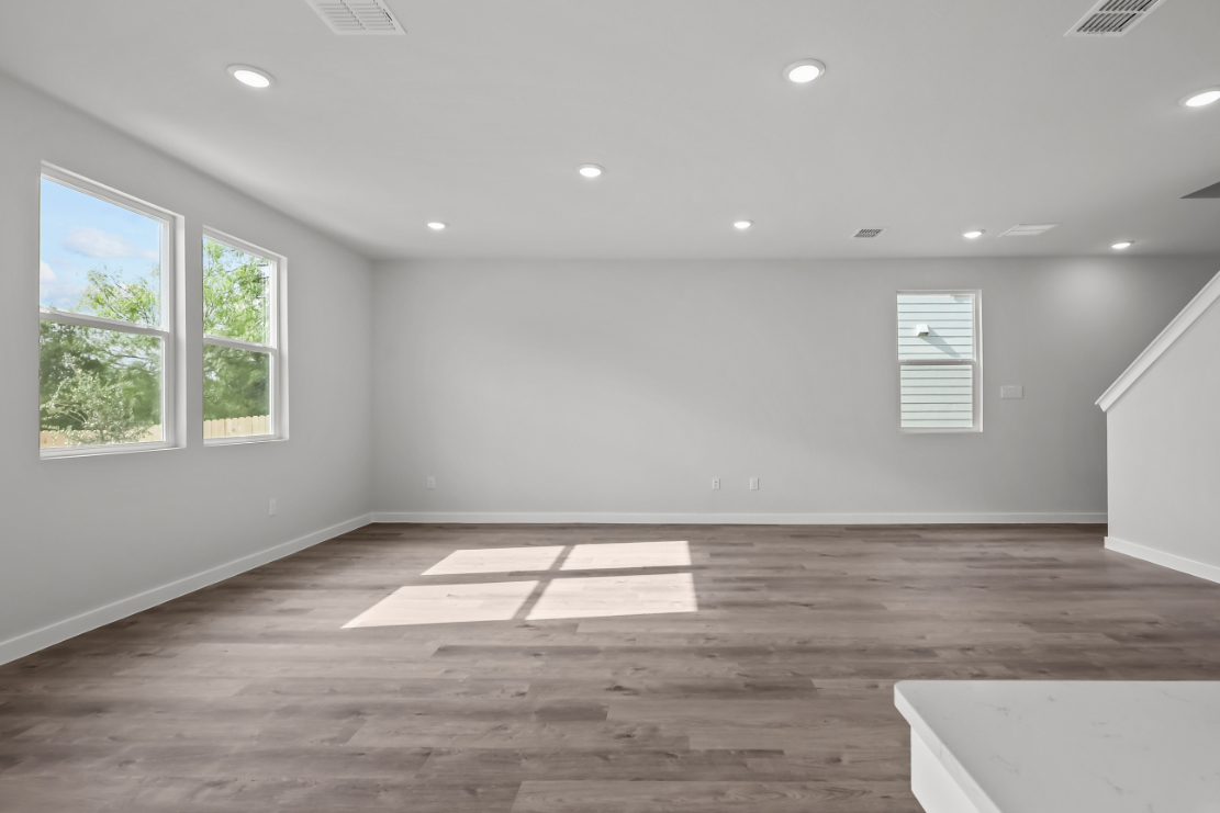 A room with a wood floor and windows.
