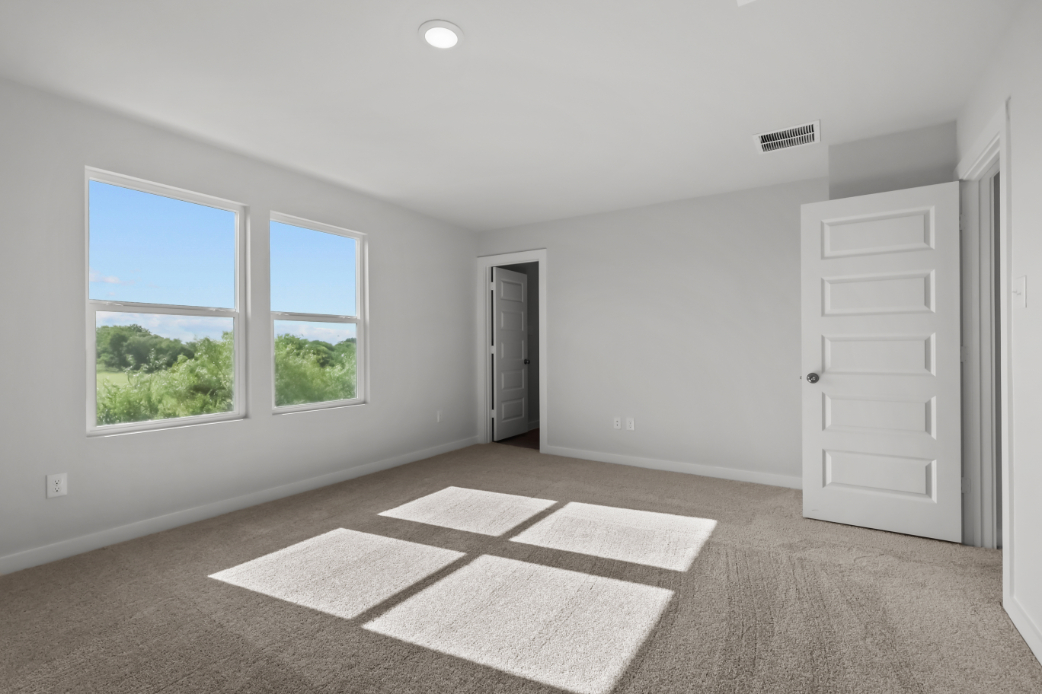 A room with a rug and a window.