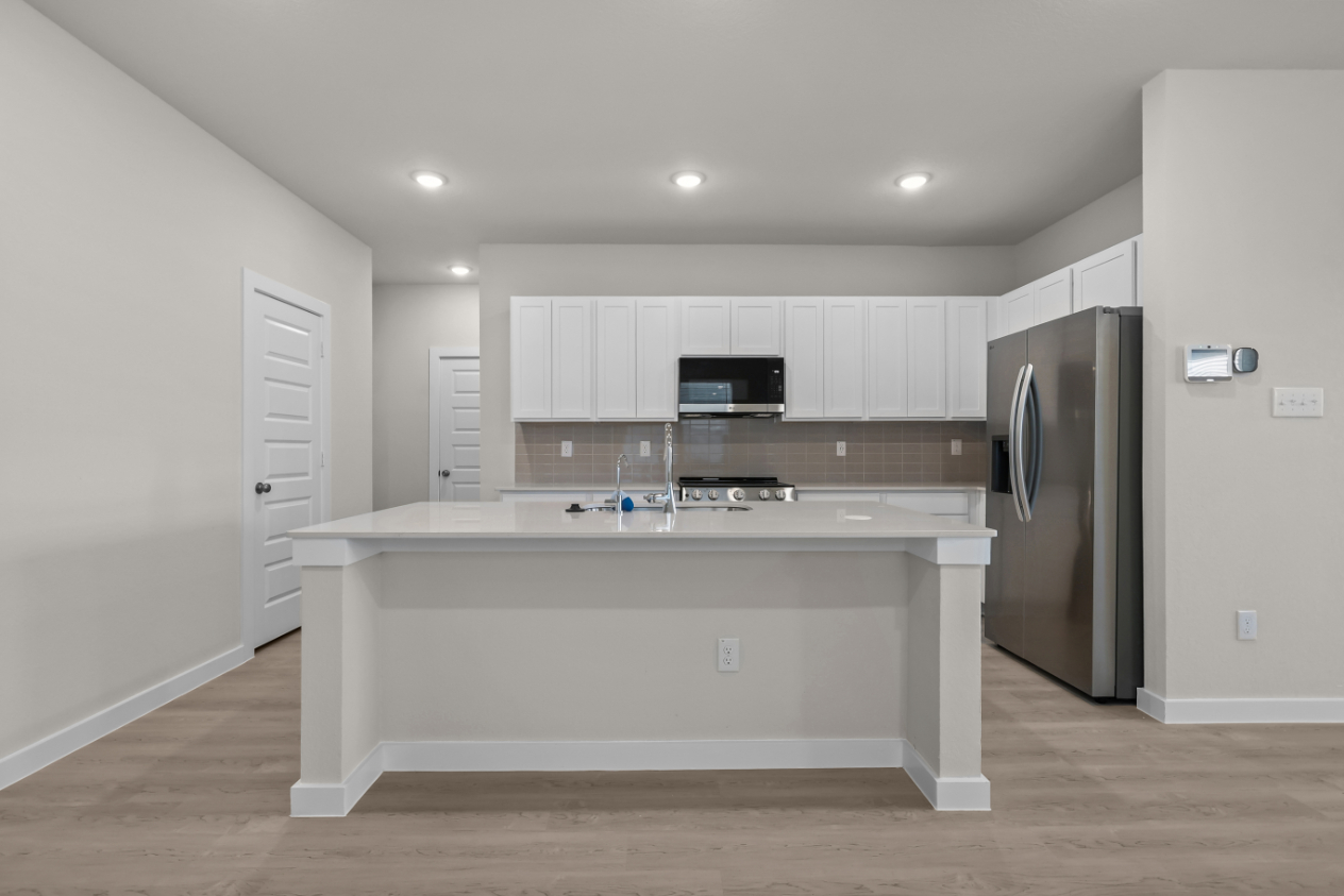 A kitchen with white cabinets.