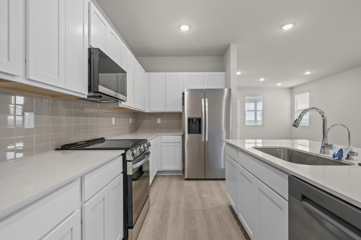 A kitchen with white cabinets.