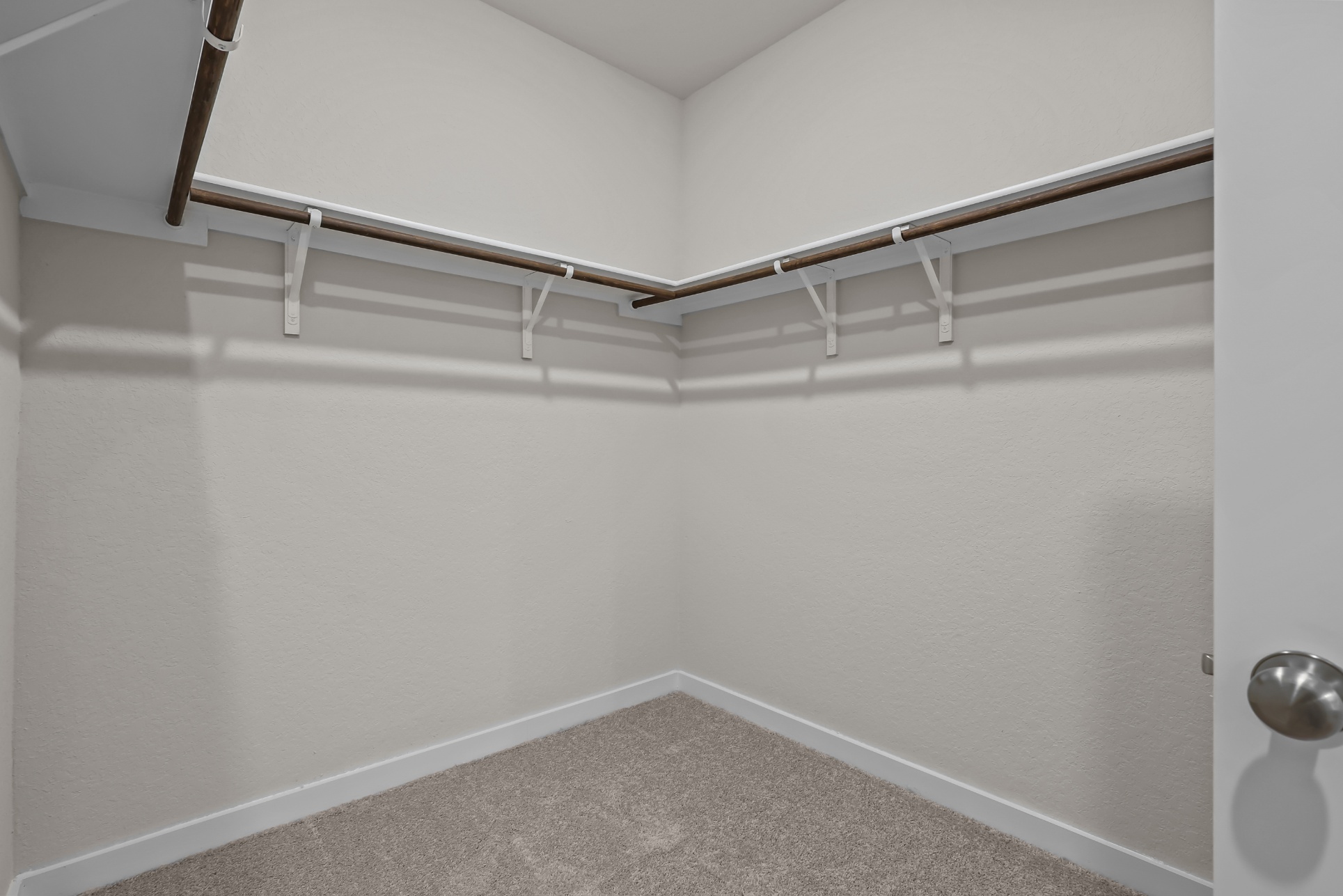 A white wall with a metal bar.