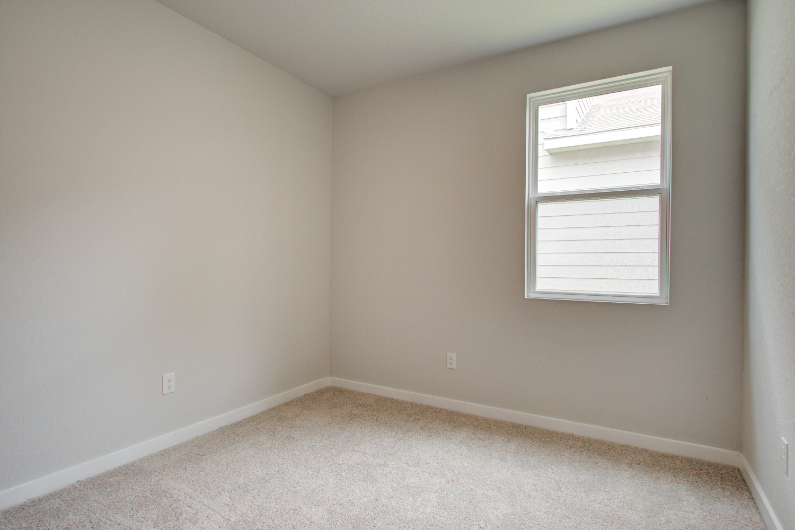 A room with a window and a carpet.