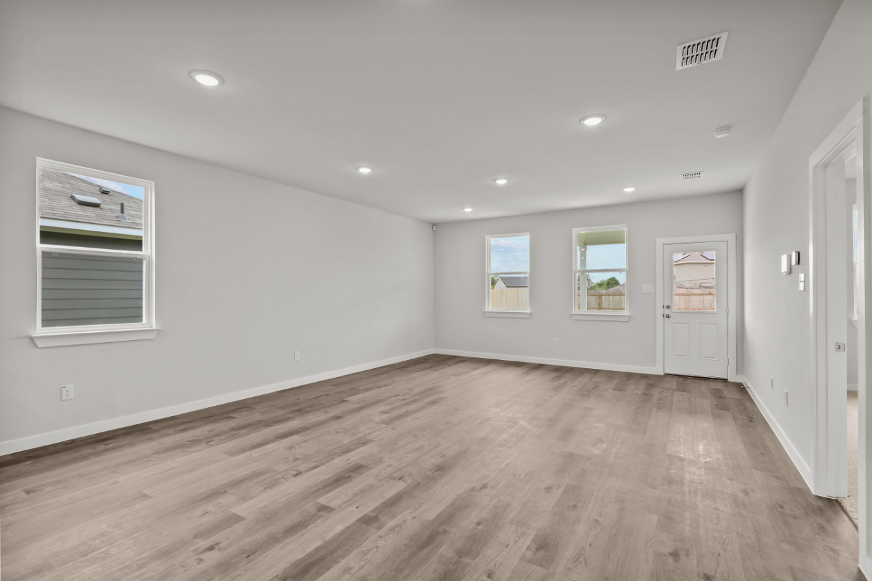 A room with white walls and wood floors.