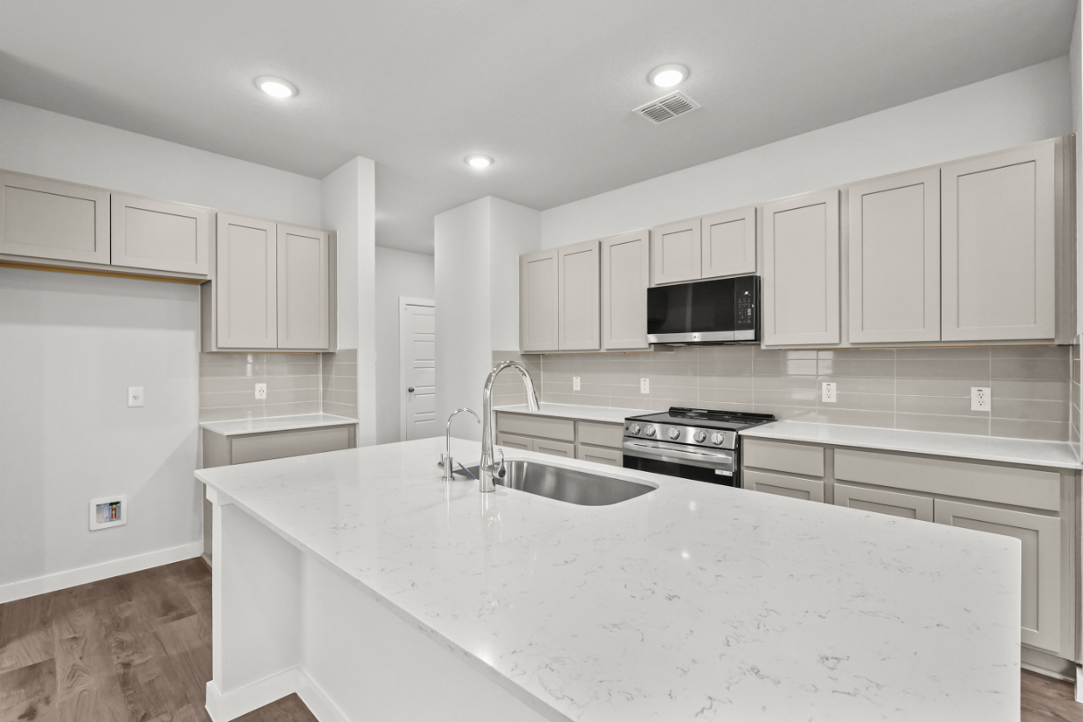 A kitchen with white cabinets.