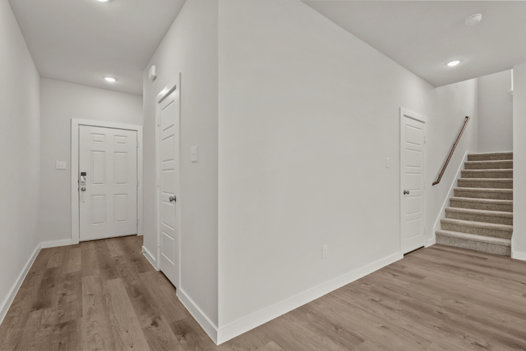 A white hallway with white doors.