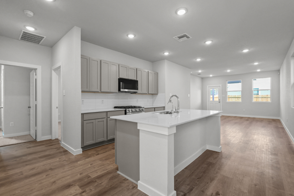 A kitchen with white cabinets.