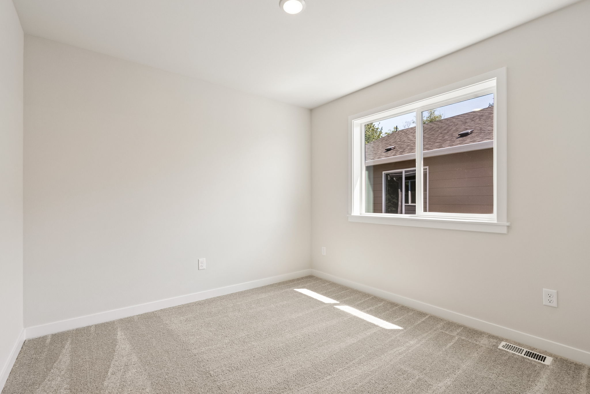A room with a window and a carpet.