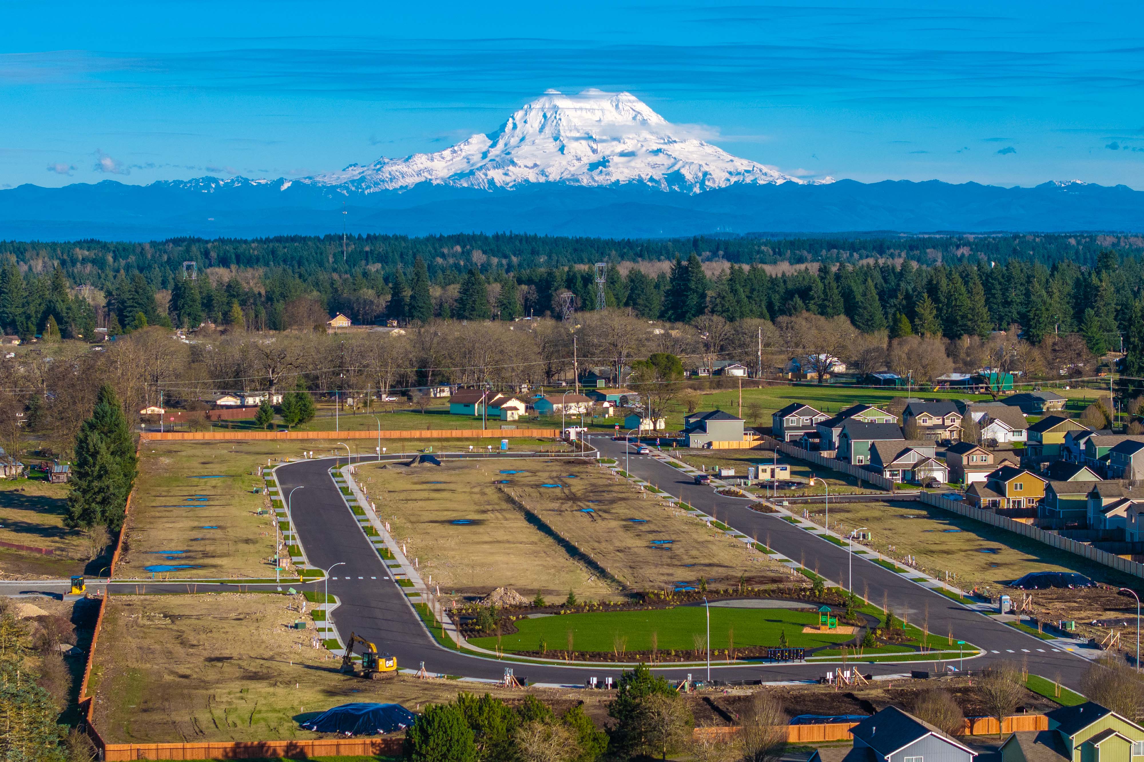 A snow covered mountain behind a town.