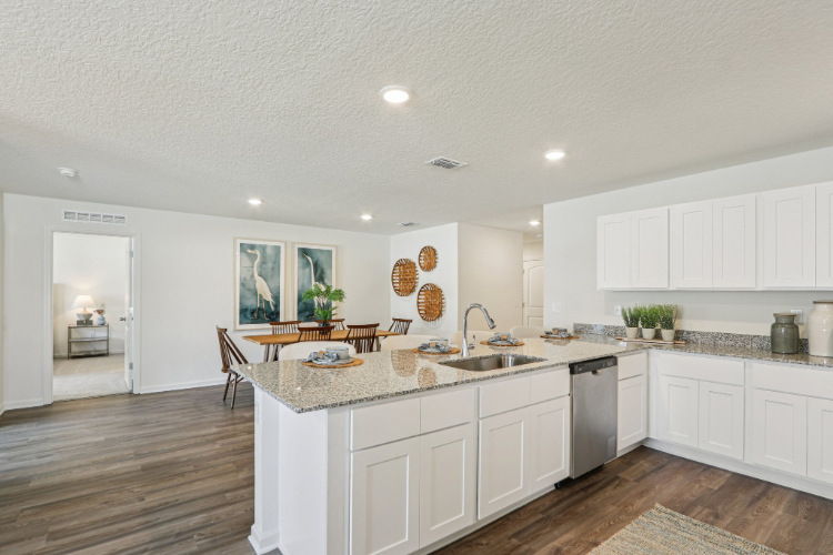 A kitchen with white cabinets.