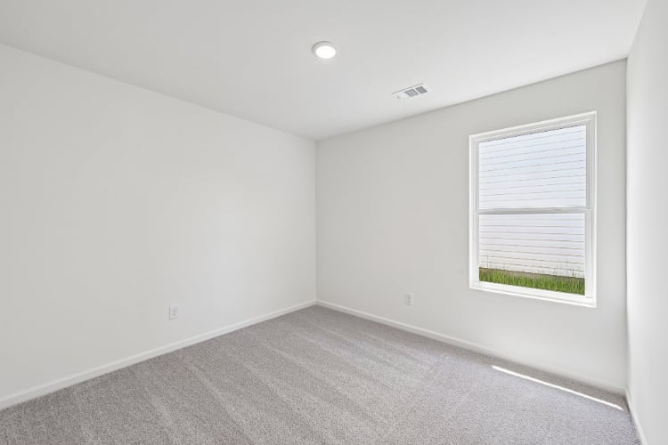 A room with a window and a carpet.