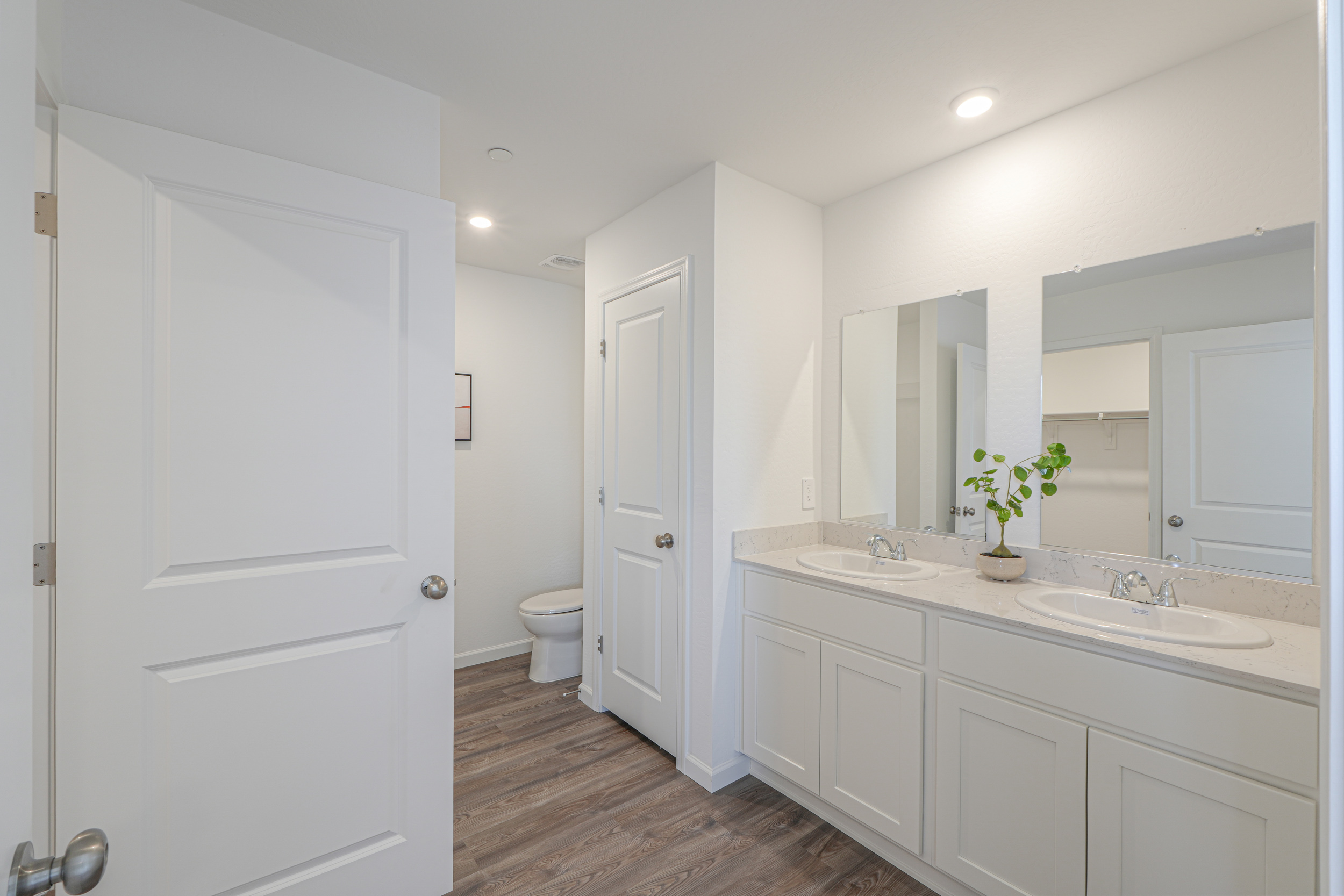 A bathroom with white cabinets.