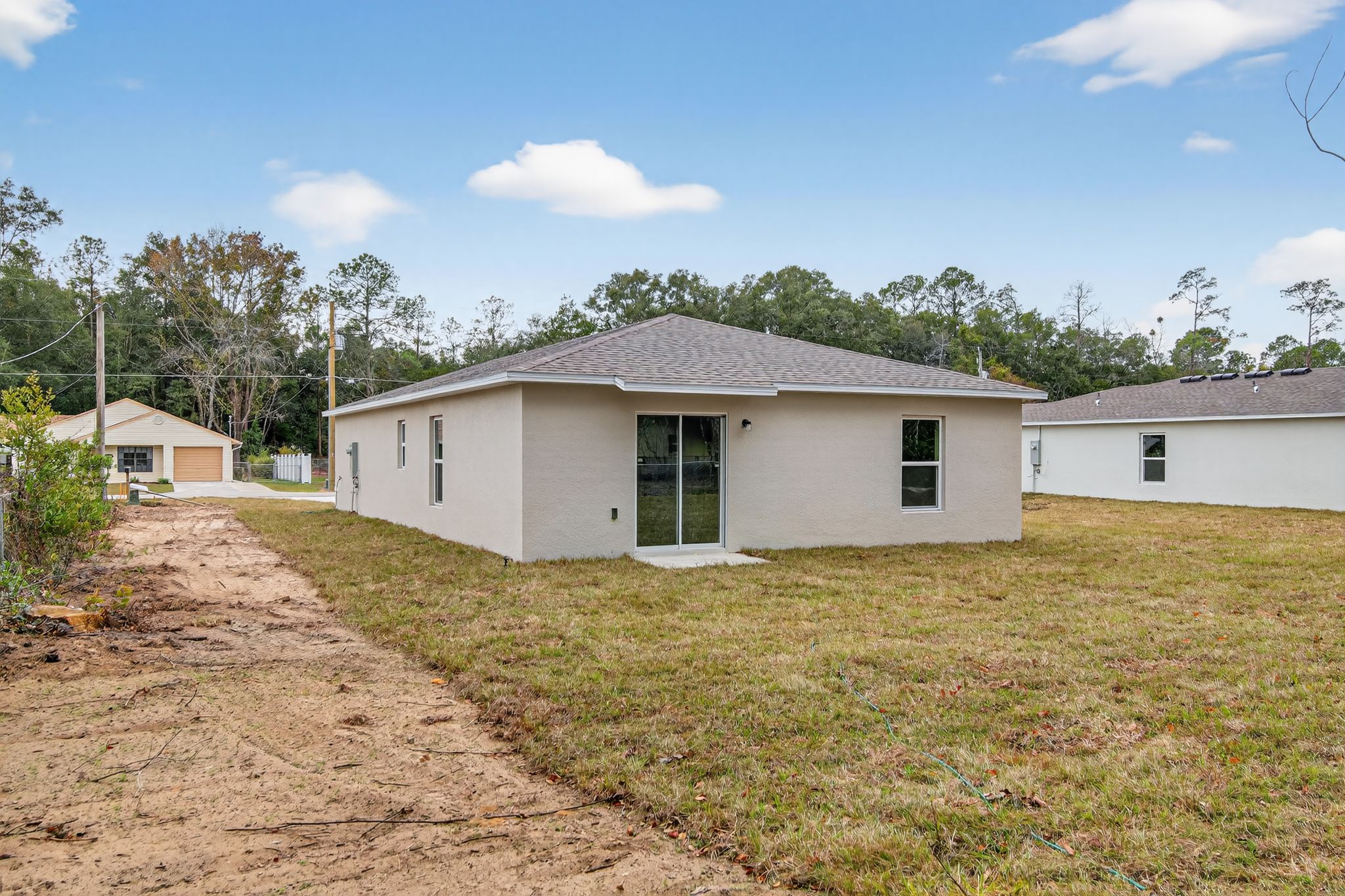 A white house with a dirt road.