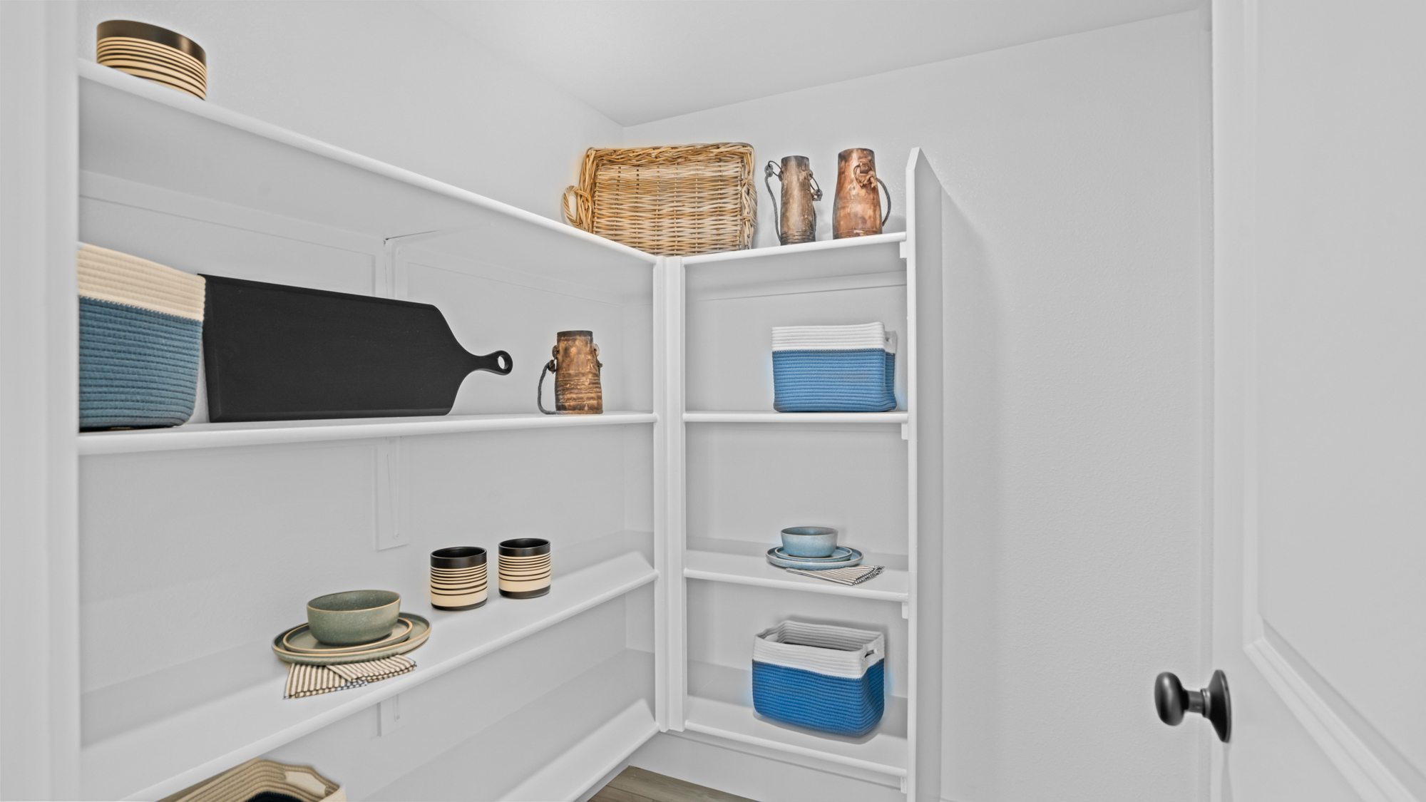 A white shelving unit with a basket and dishes.